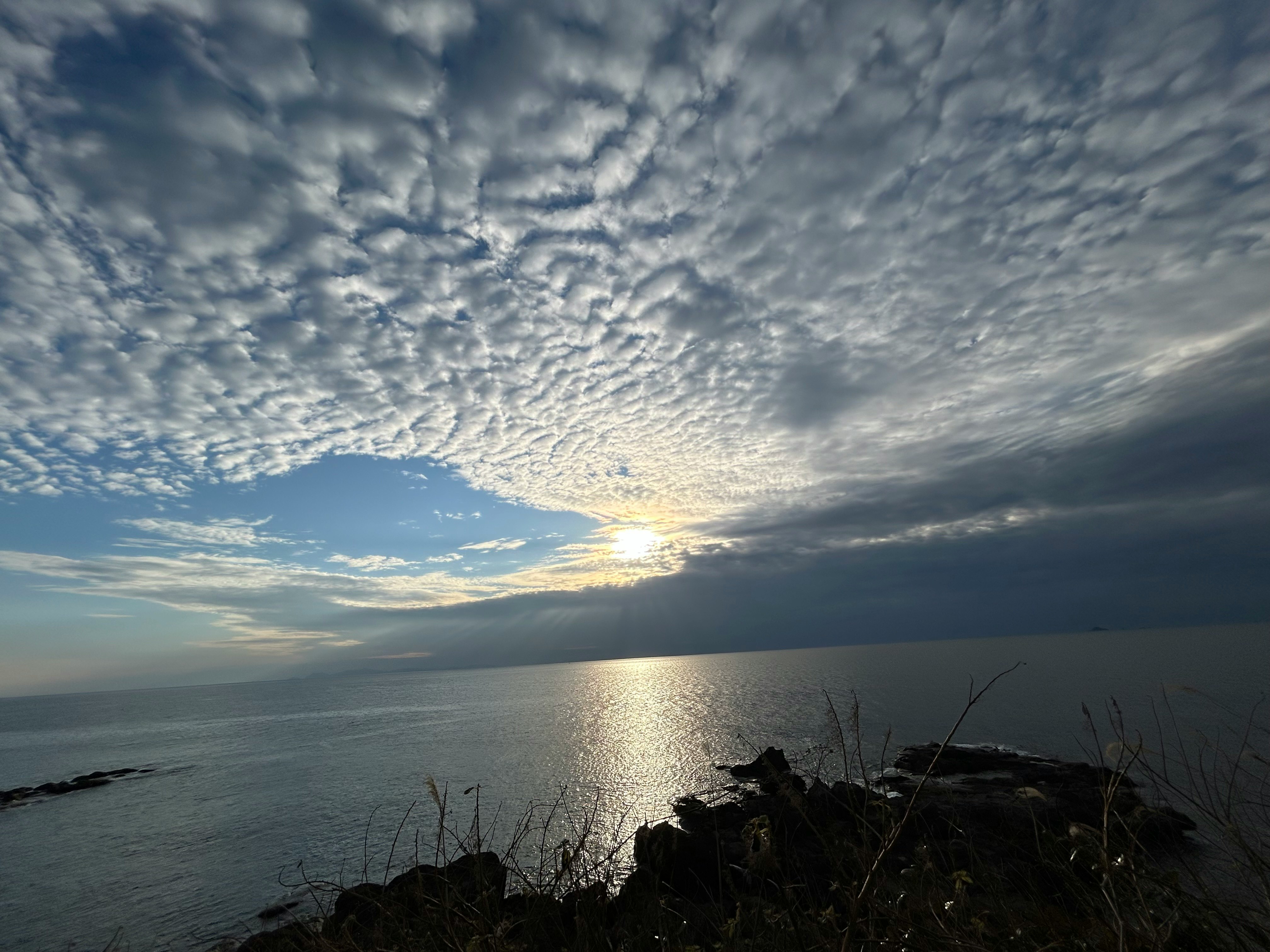 夕日に照らされた海と岩場の海岸線の風景