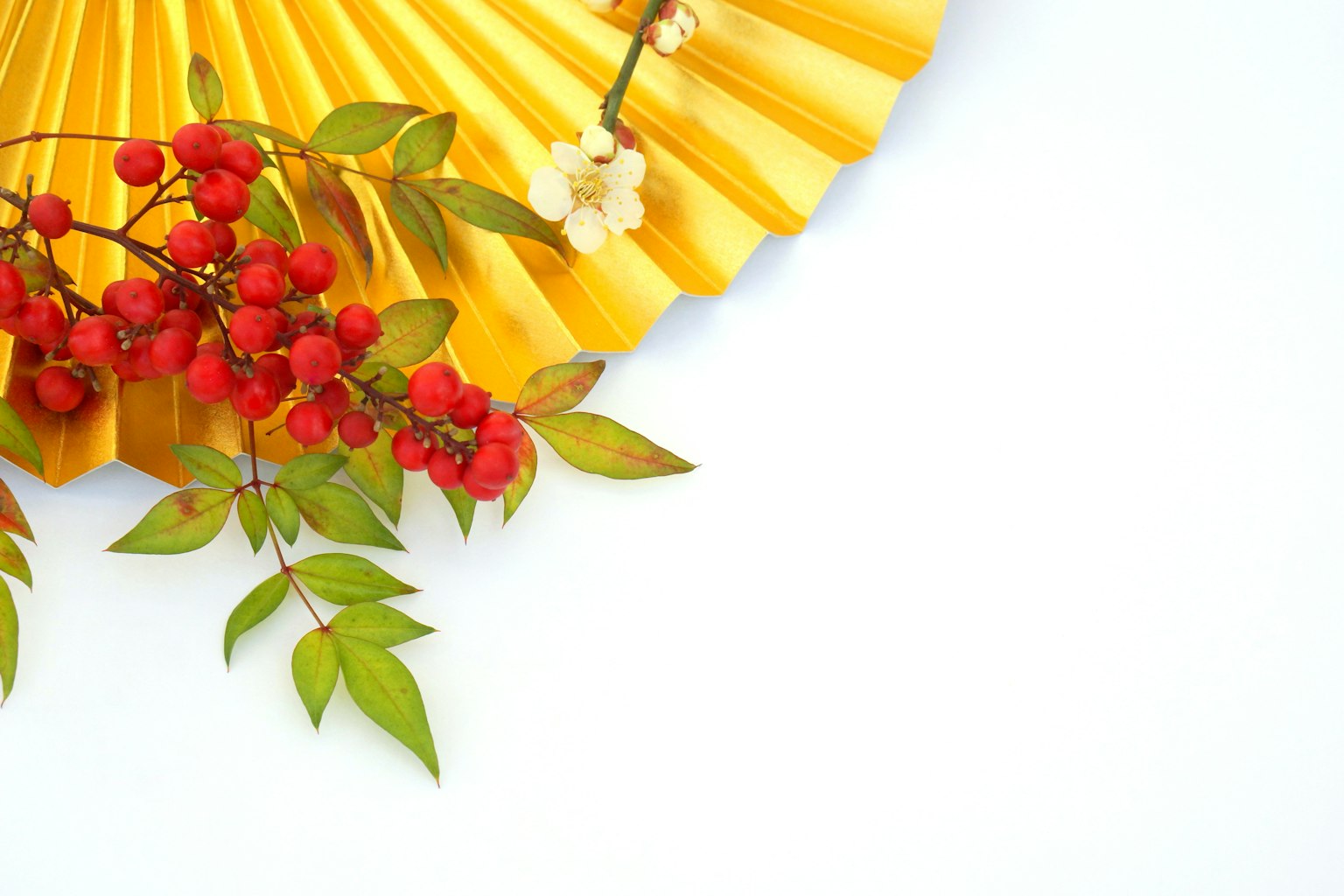 Dekoratives Bild mit einem gelben Fächer und Zweigen mit roten Beeren
