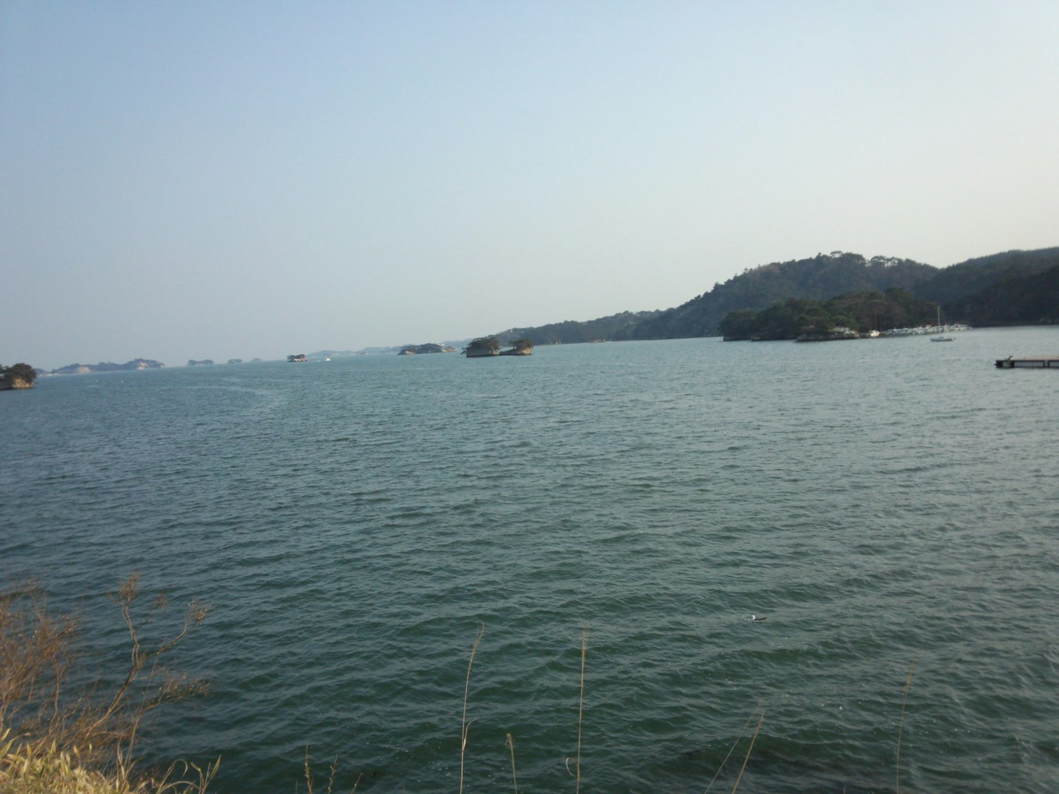 Calm sea with small islands wide water surface and blue sky