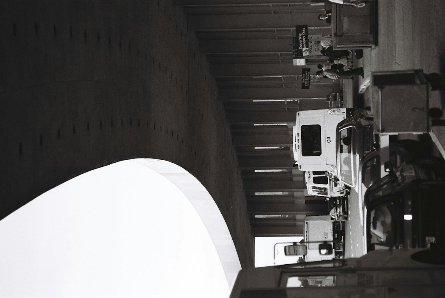 Trucks and vehicles parked under a black and white tunnel