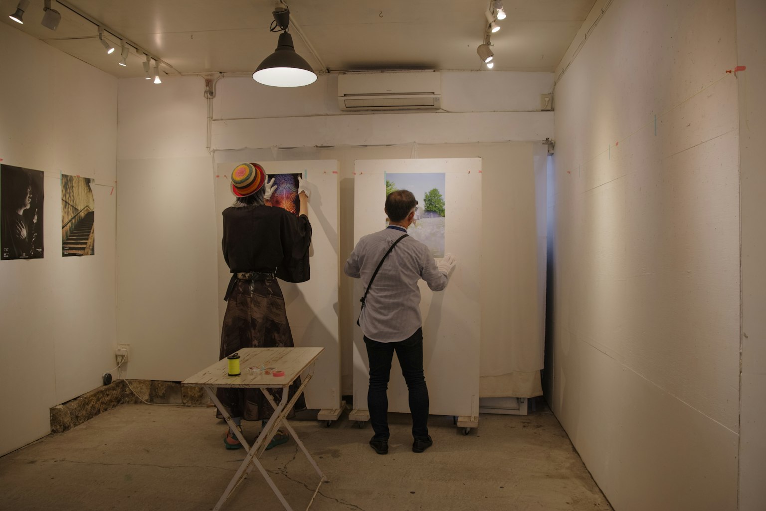 Two visitors observing artwork in an art gallery setting