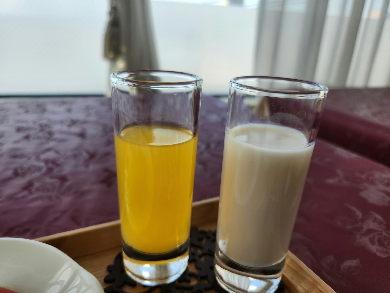 兩個盛有黃色果汁和白色飲料的酒杯