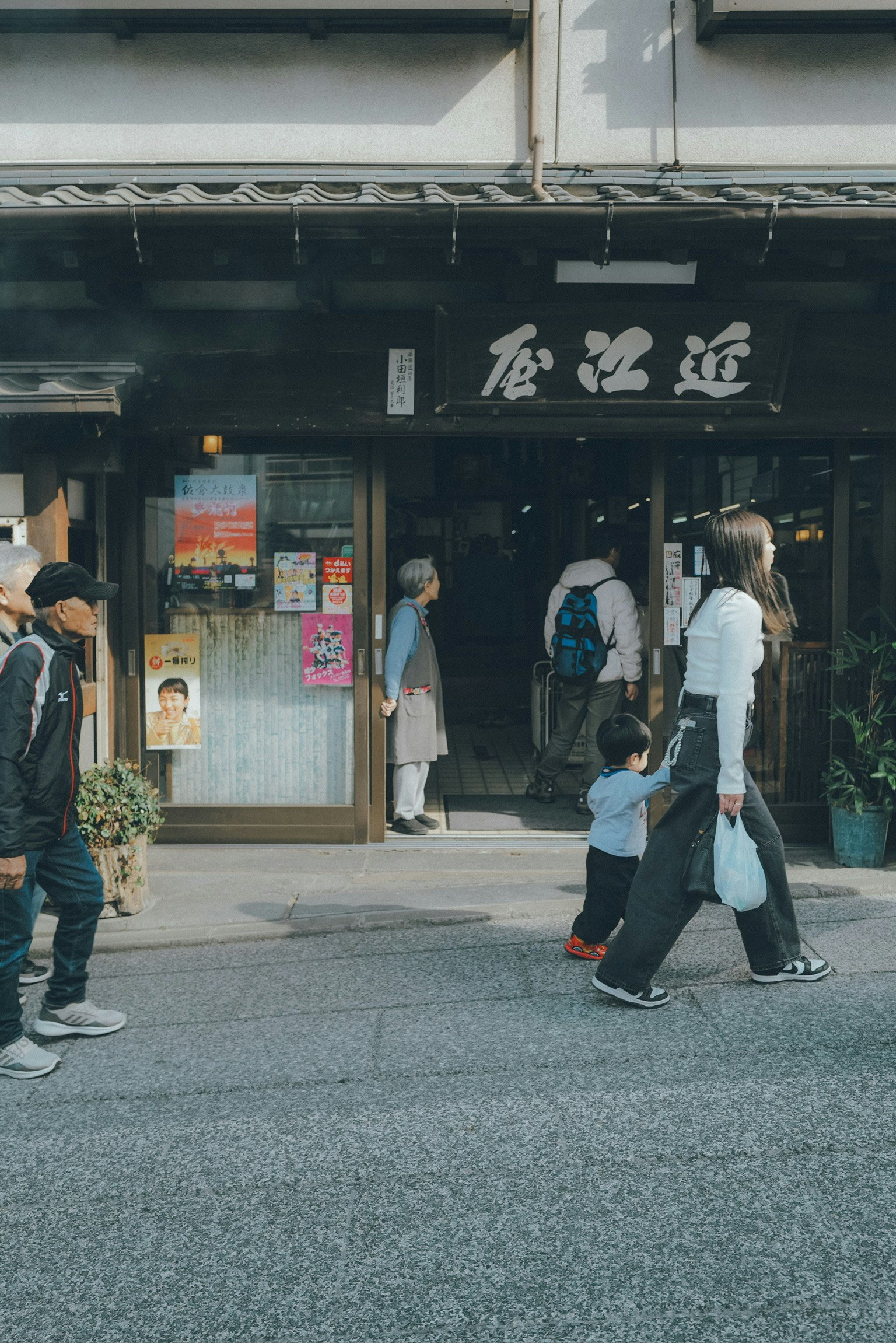 路地の商店街入口で人が行き交う街並み