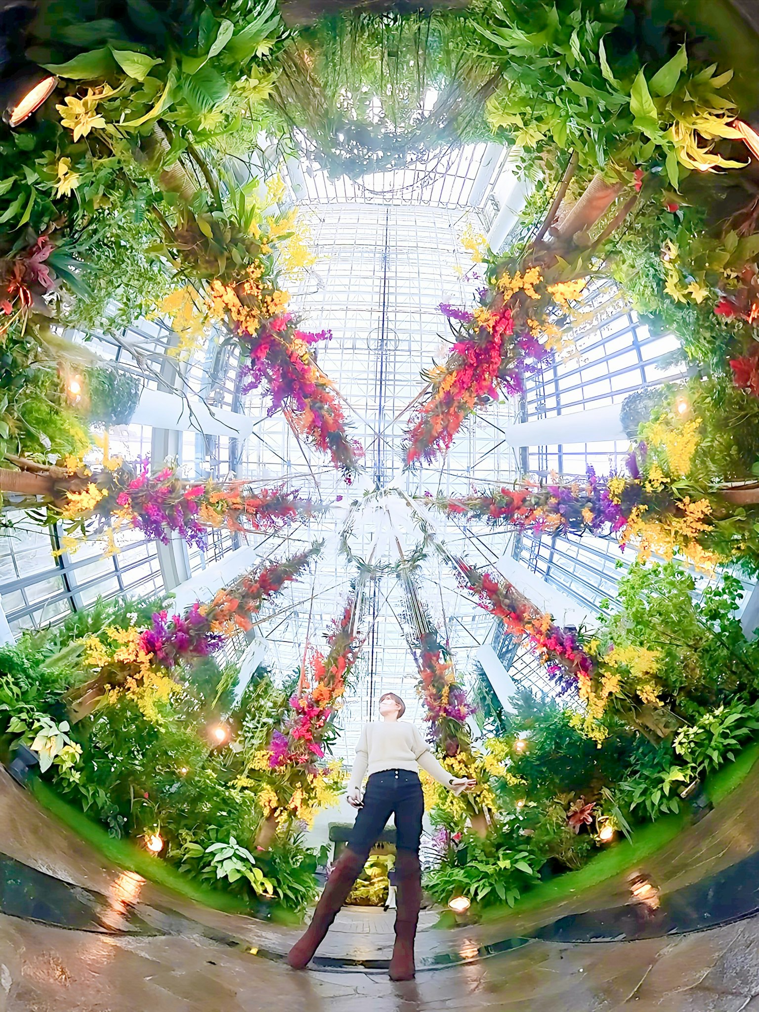 Personne posant dans une magnifique serre remplie de fleurs vibrantes