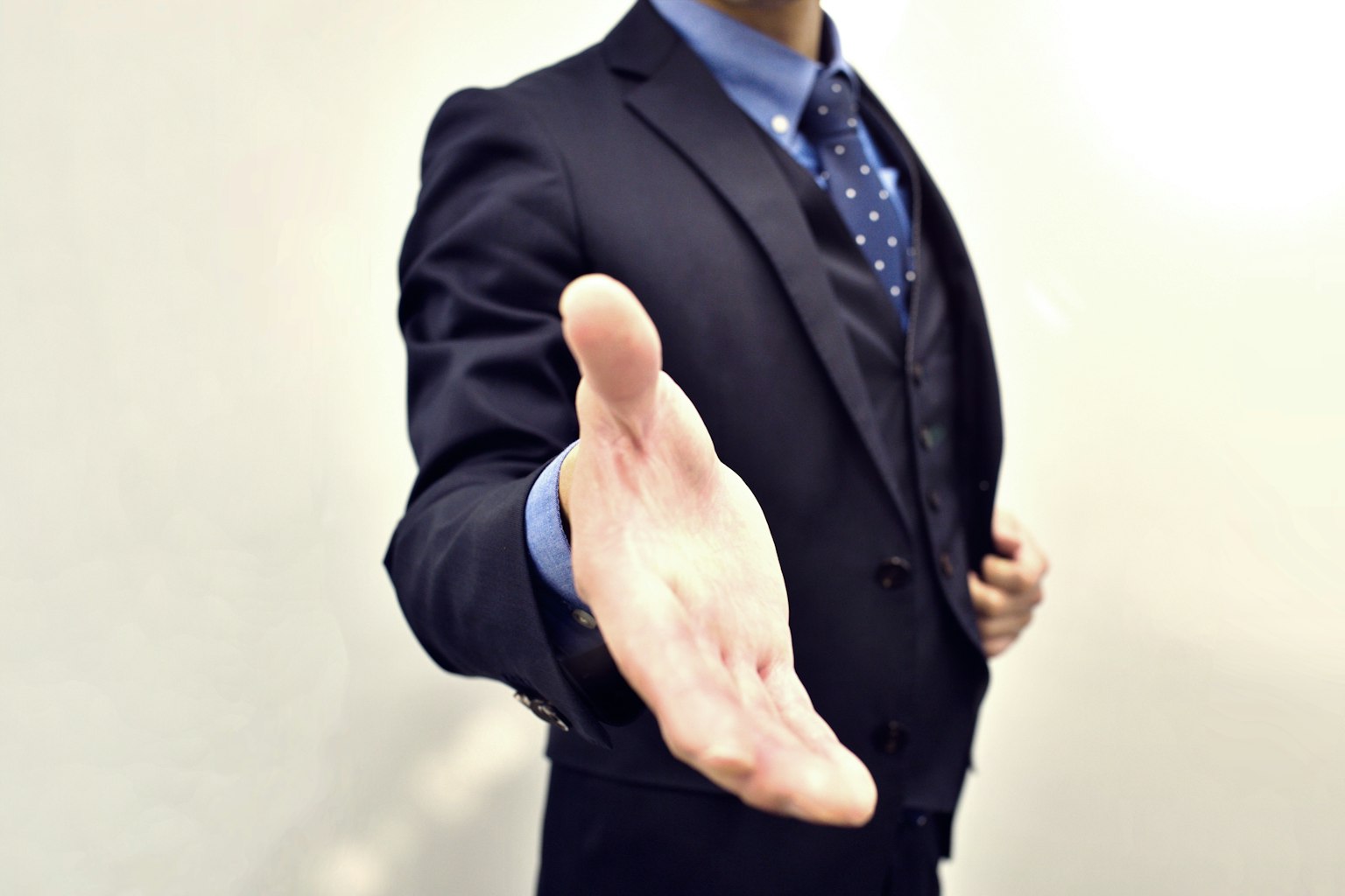 Un uomo in giacca che allunga la mano per una stretta di mano