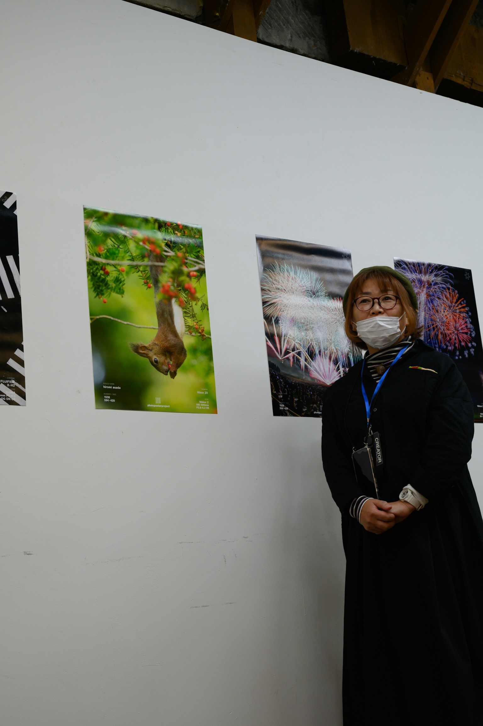 女性站在展览中的艺术海报前