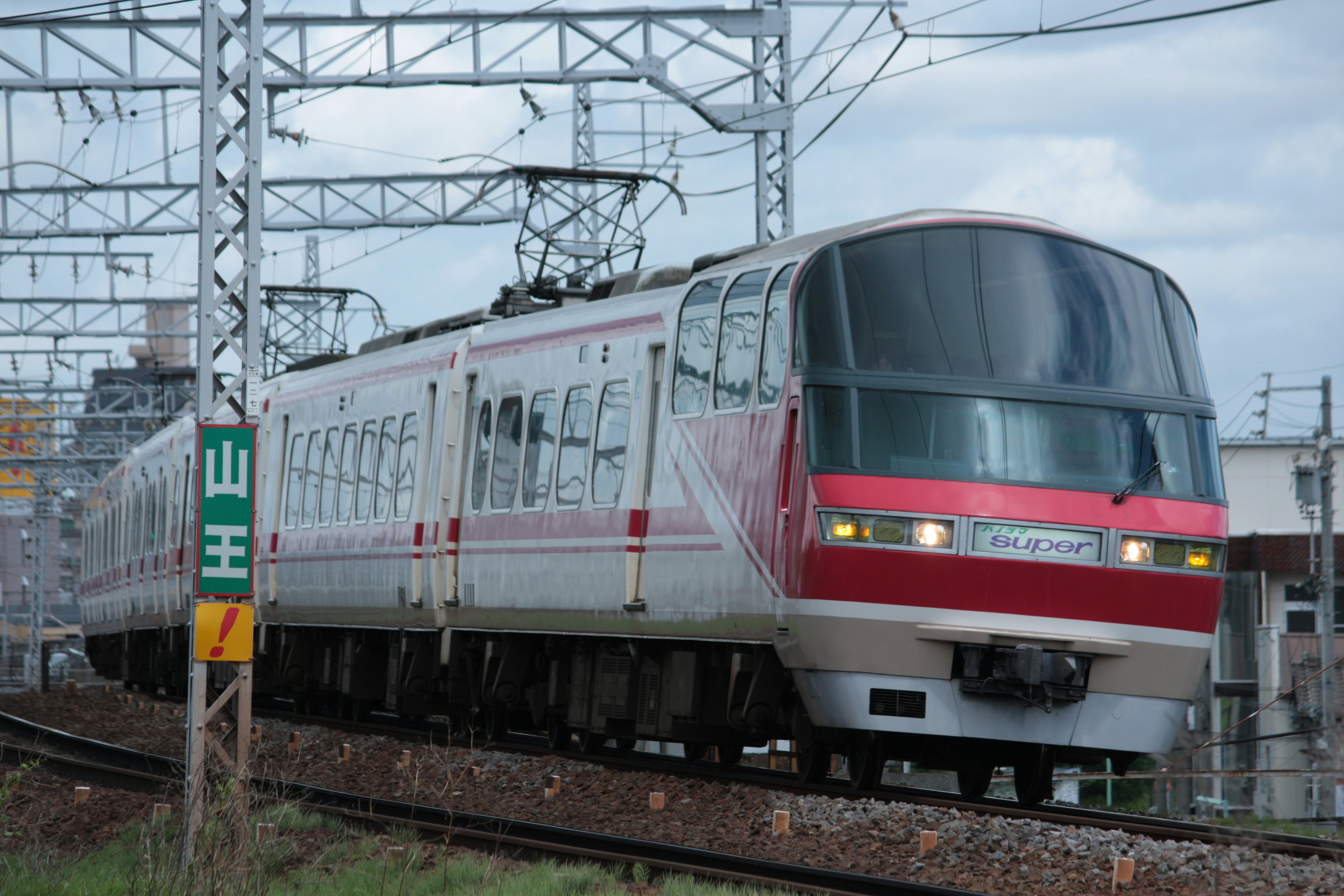 架線と鉄骨のある駅線路を走る車両