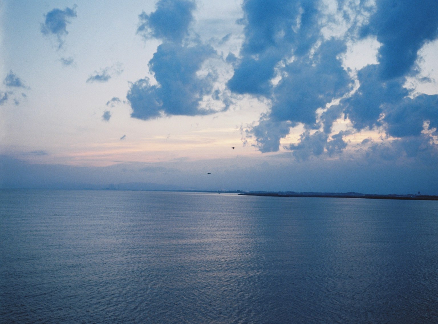 宁静的黄昏海景，蓝色海水和散落的云朵