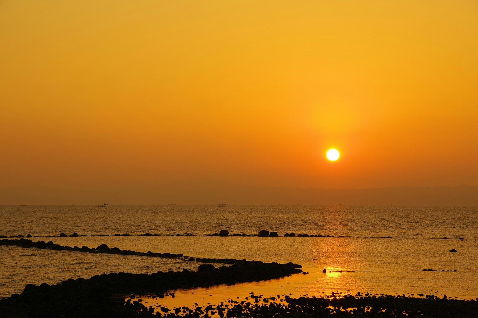 Wunderschöner Sonnenuntergang über dem Ozean mit gelbem Himmel und ruhigem Wasser