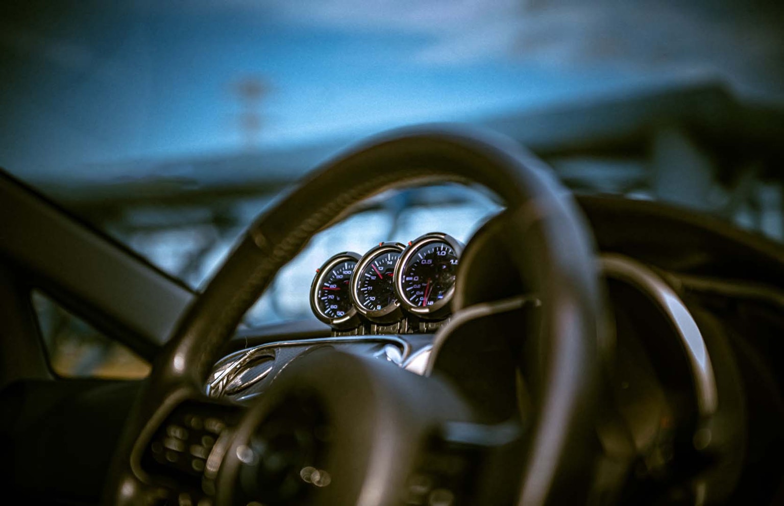 Vue intérieure d'une voiture avec un volant et des jauges bleues