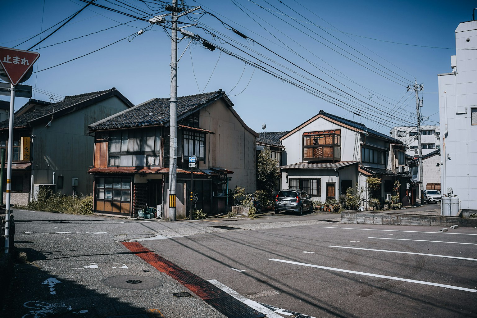 Intersection dans un quartier résidentiel avec des maisons japonaises traditionnelles et des bâtiments modernes