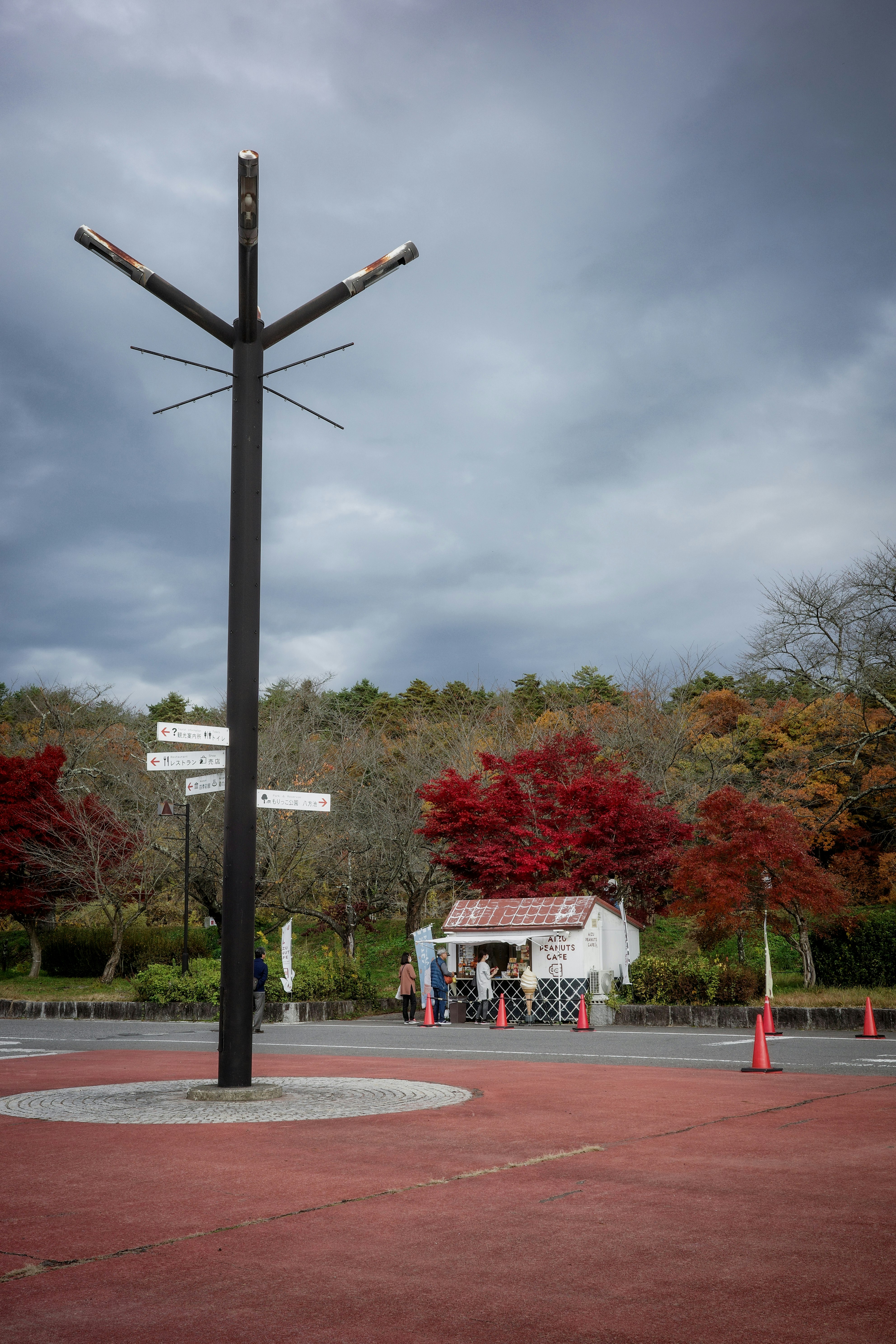 広場に立つ大きな風見鶏と紅葉の並木