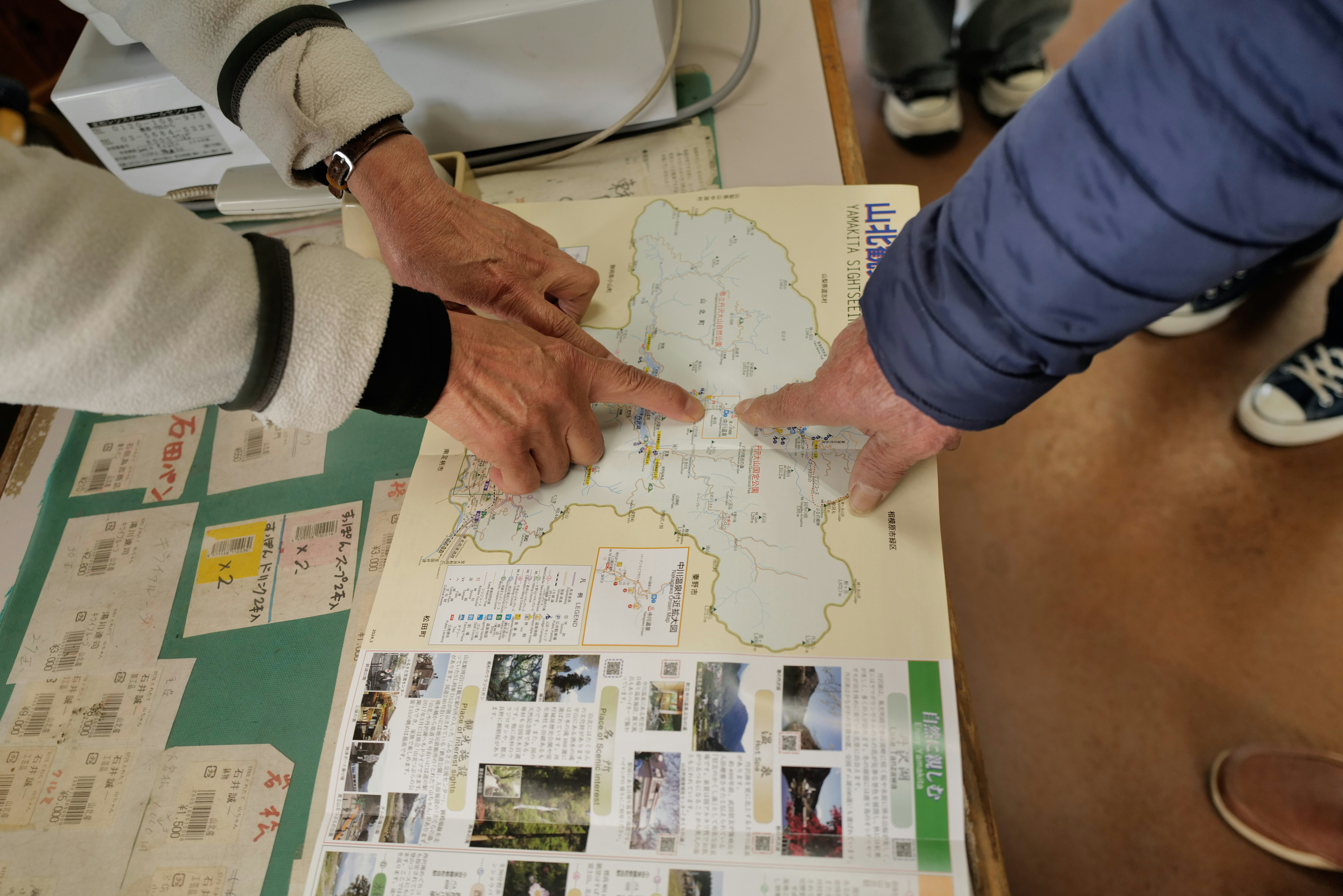 地図を囲んで指さし確認する人たちの会議風景