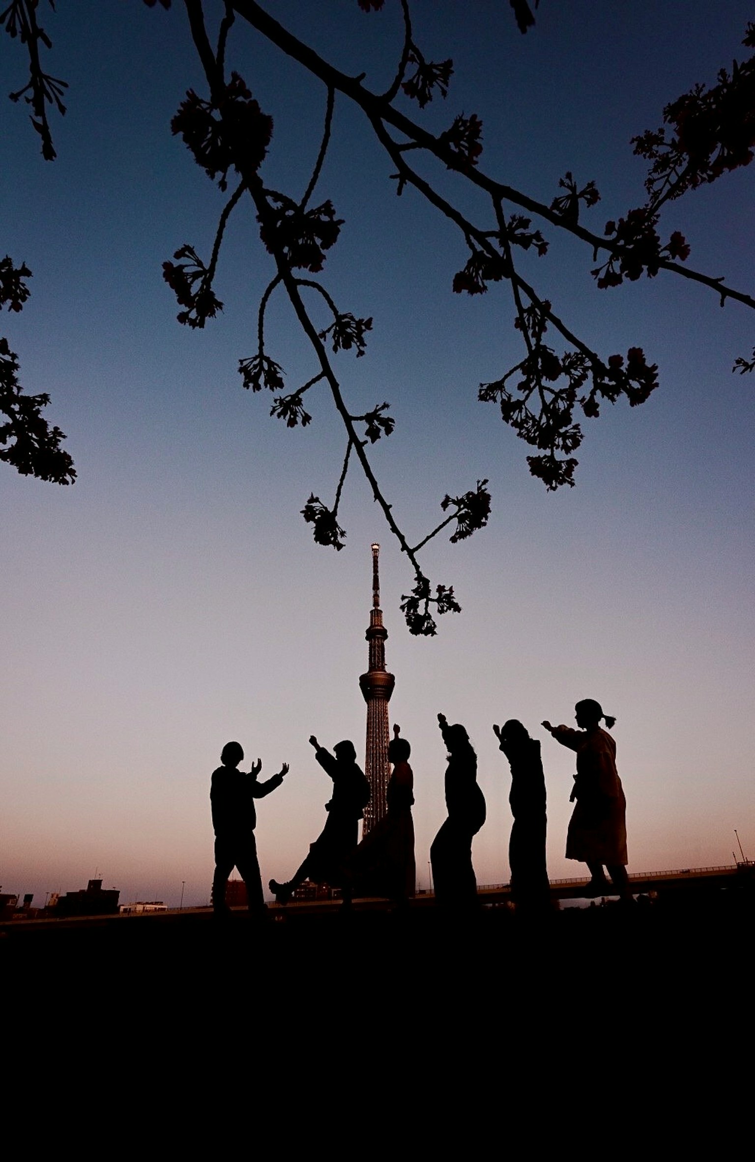 夕暮れ時に東京スカイツリーを背景にした人々のシルエット