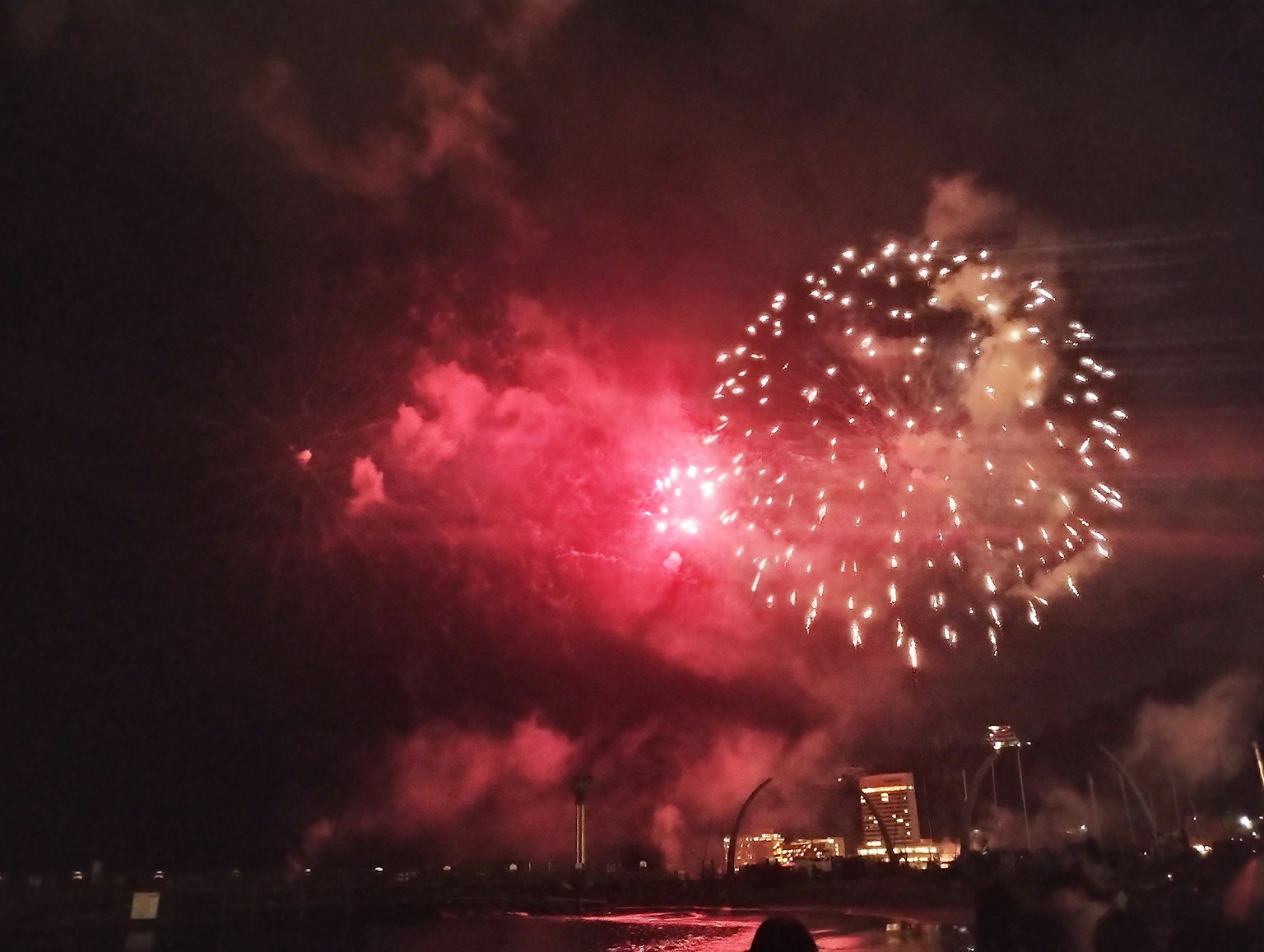 夜空中绽放的红色烟花和烟雾