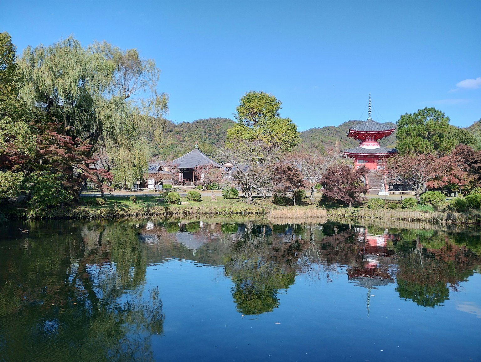 Bâtiments japonais traditionnels et pagode rouge reflétés dans un étang serein