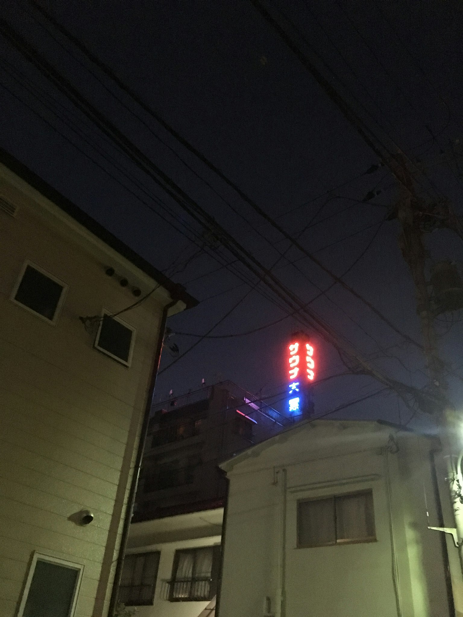 Insegna al neon luminosa tra edifici residenziali di notte