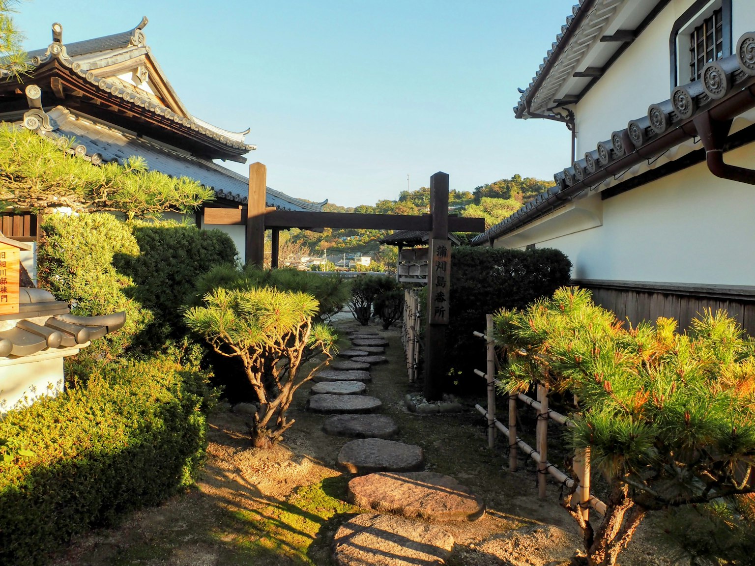 Jalan setapak di taman Jepang dengan batu dan vegetasi rimbun