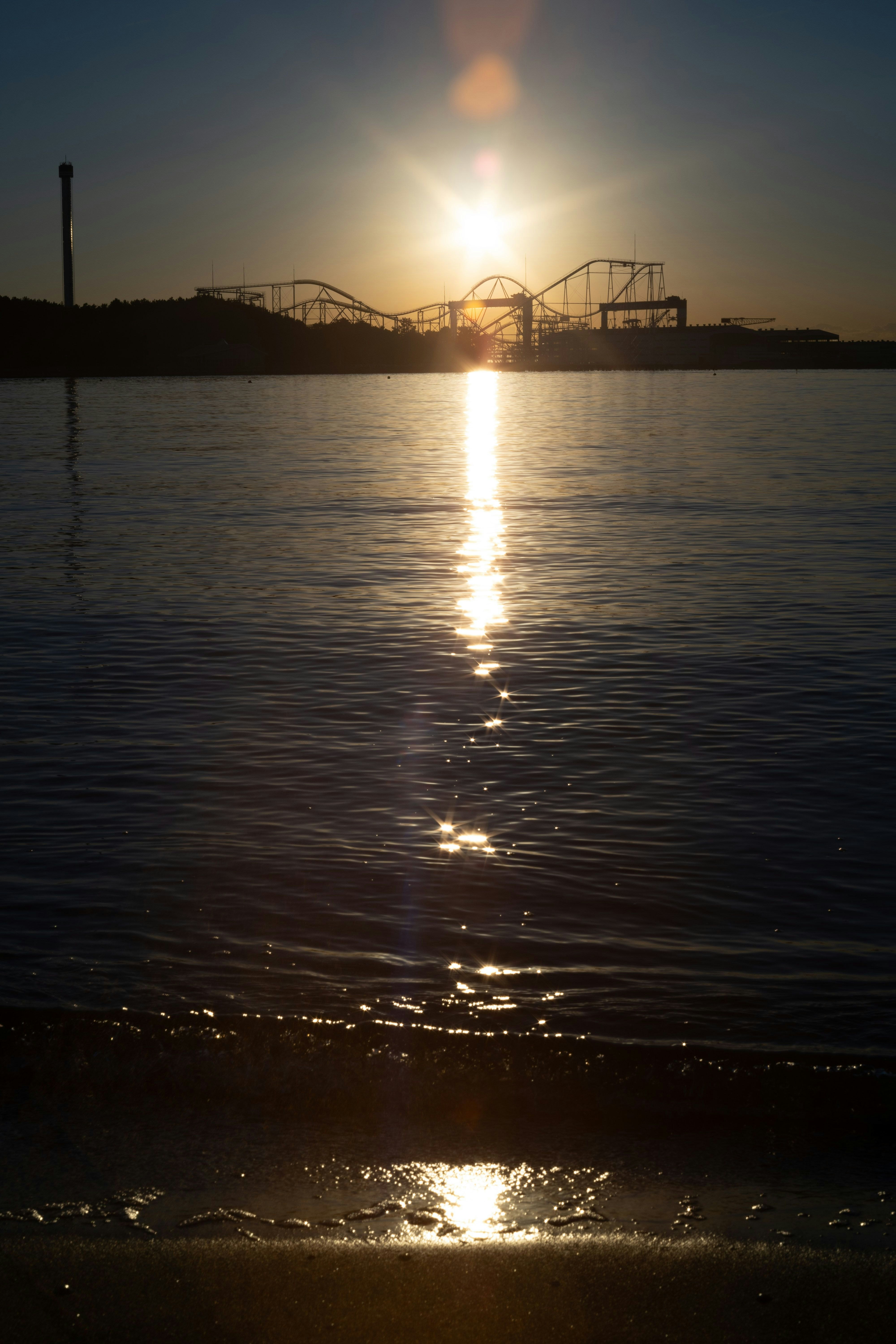 夕暮れの水面に映る橋のシルエット