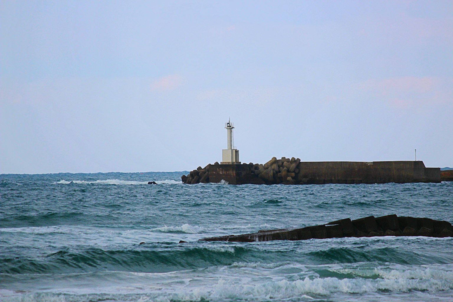 Scena costiera con un faro e onde leggere