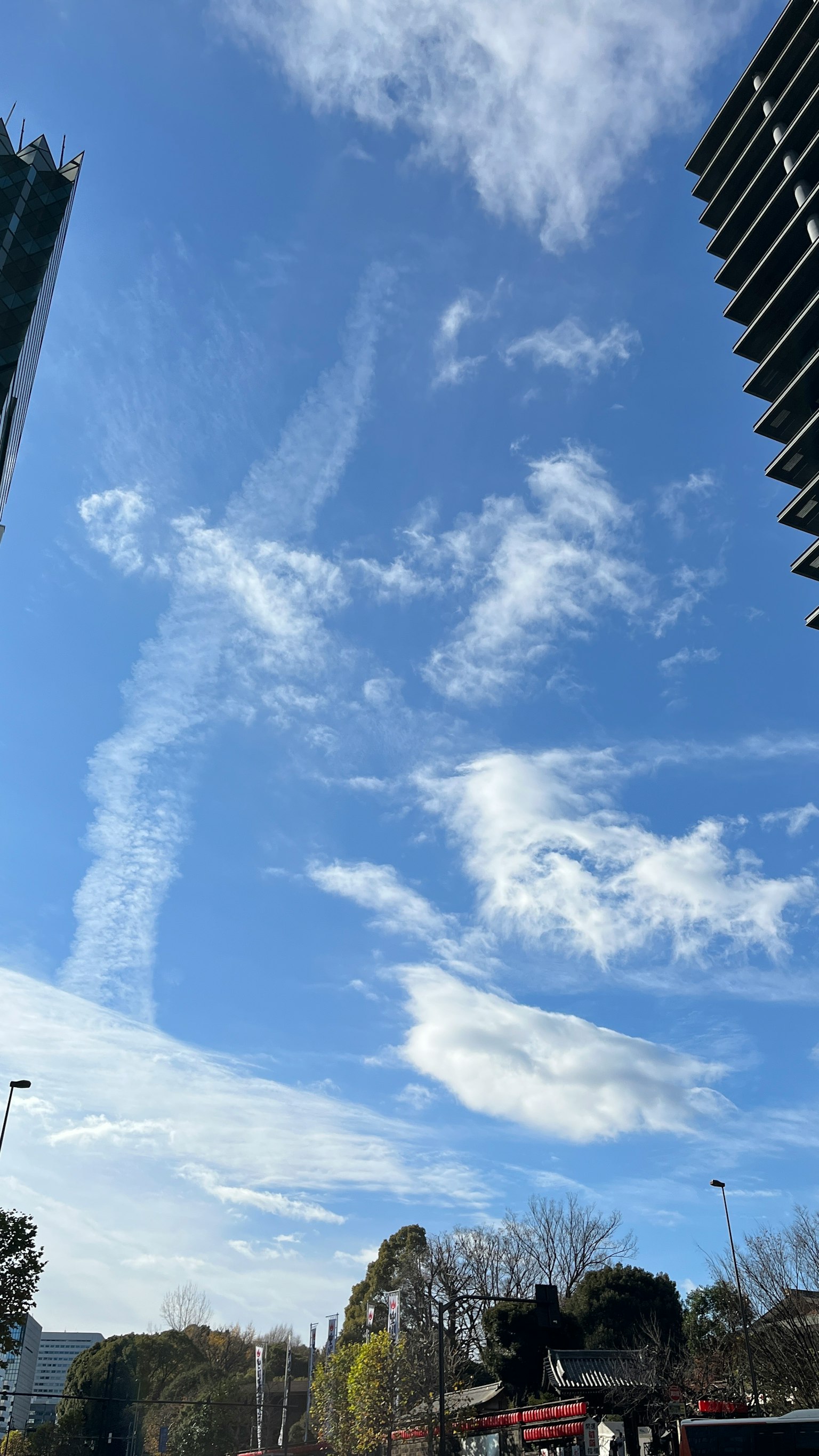 Landscape with blue sky and white clouds tall buildings flanking the view