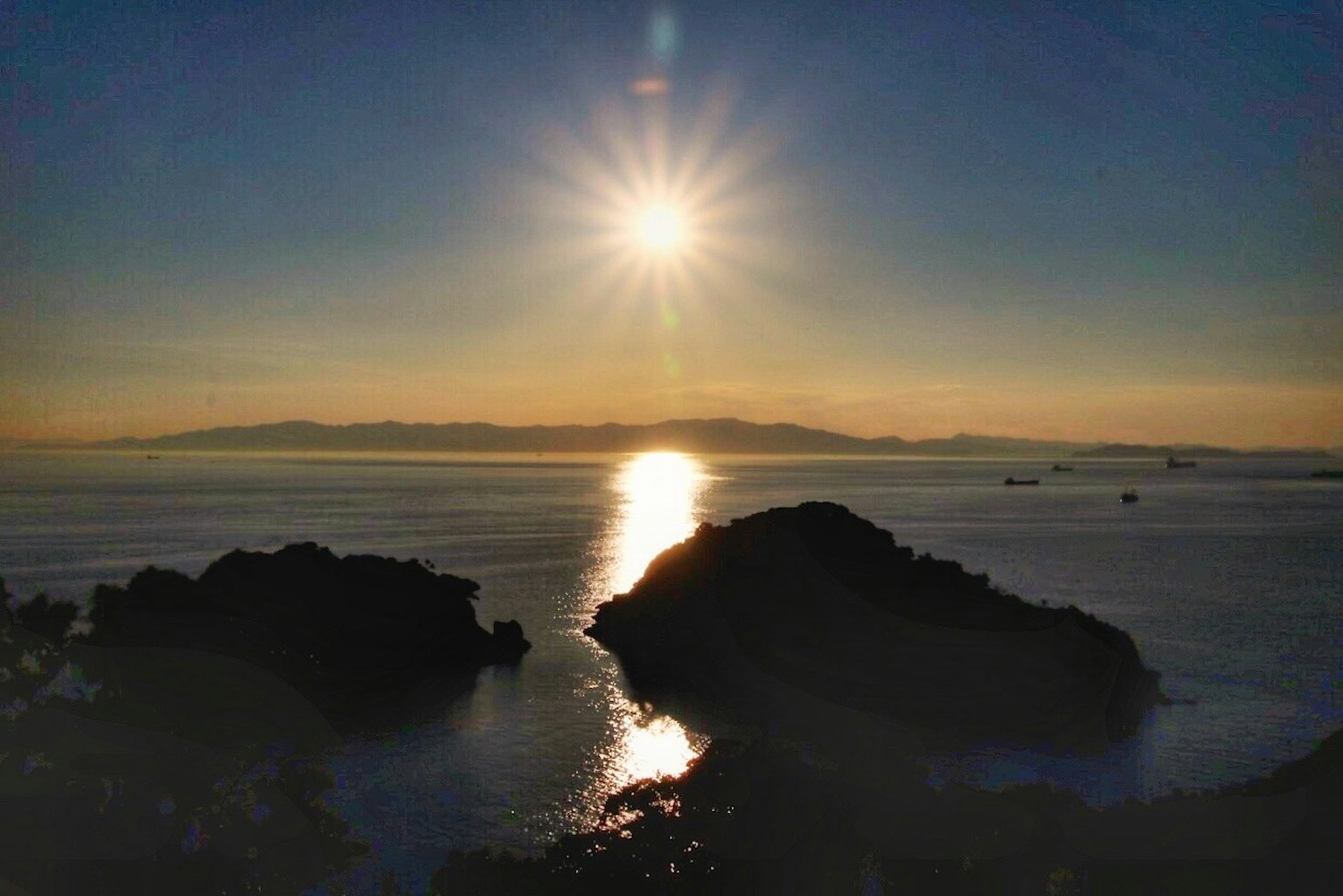 Bellissimo tramonto che si riflette sul mare silhouette di rocce