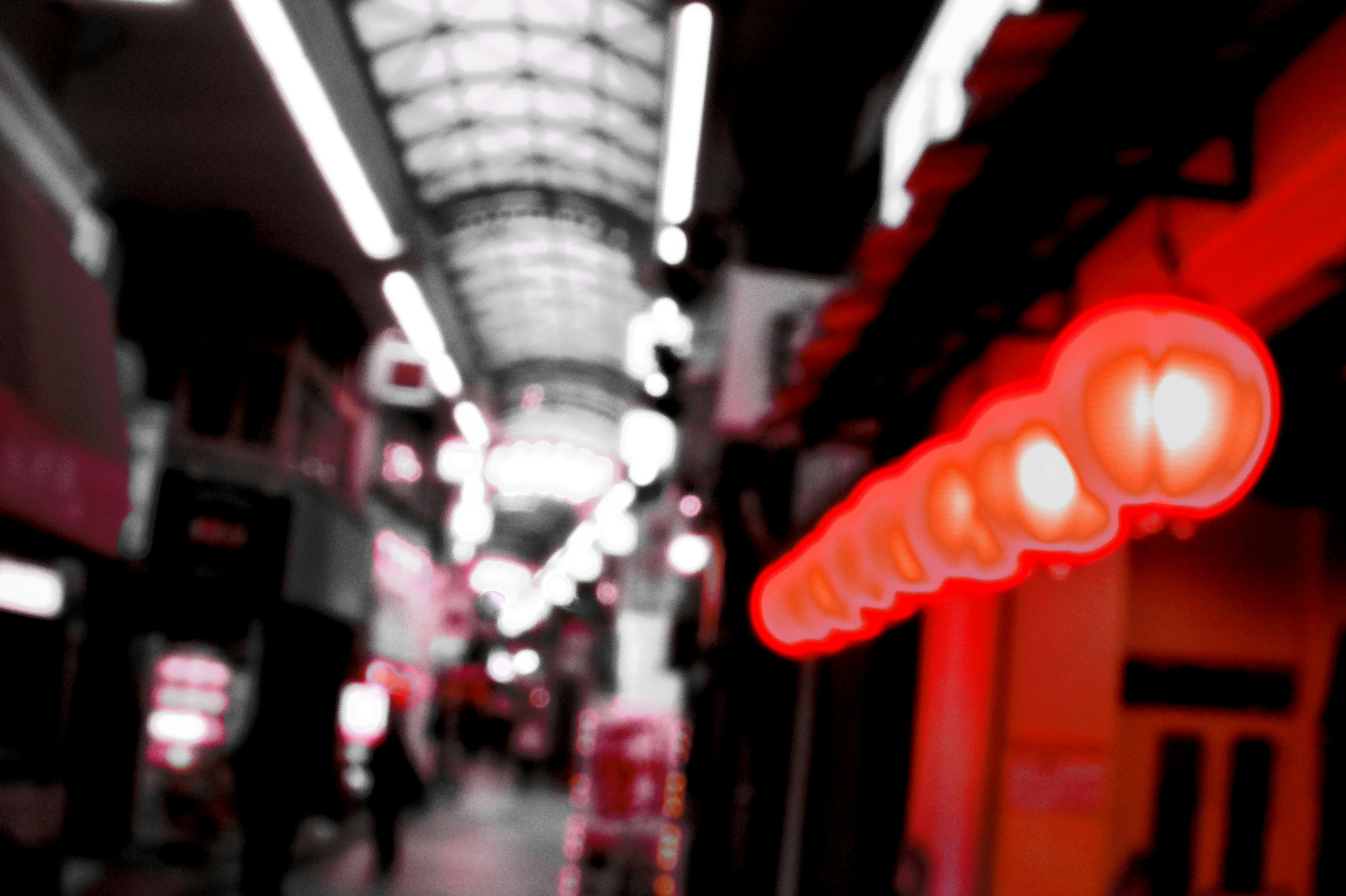 赤い光のクラゲが浮かぶ夜の商店街の路地