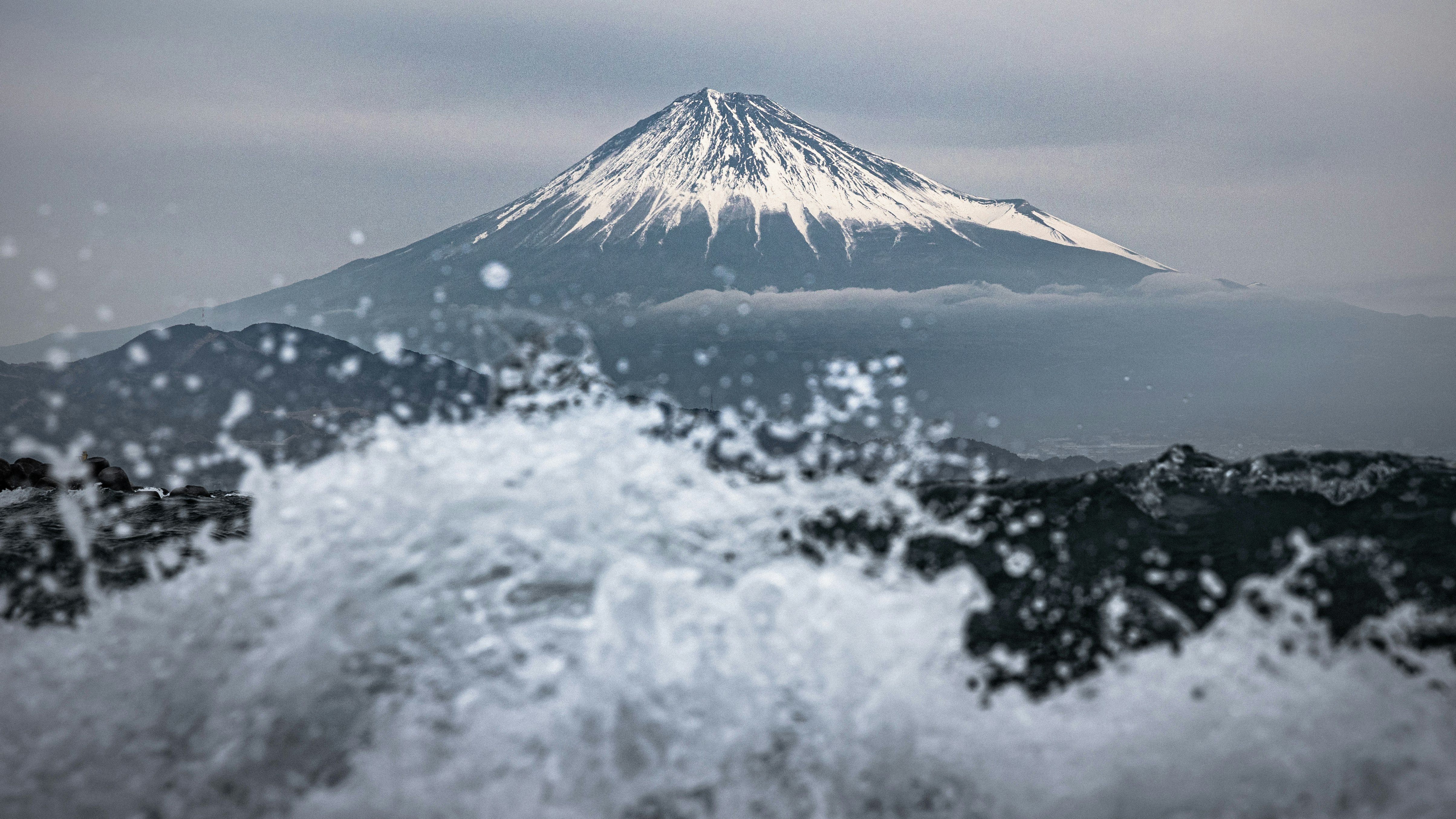 Scène côtière avec des éclaboussures d’eau et le mont Fuji