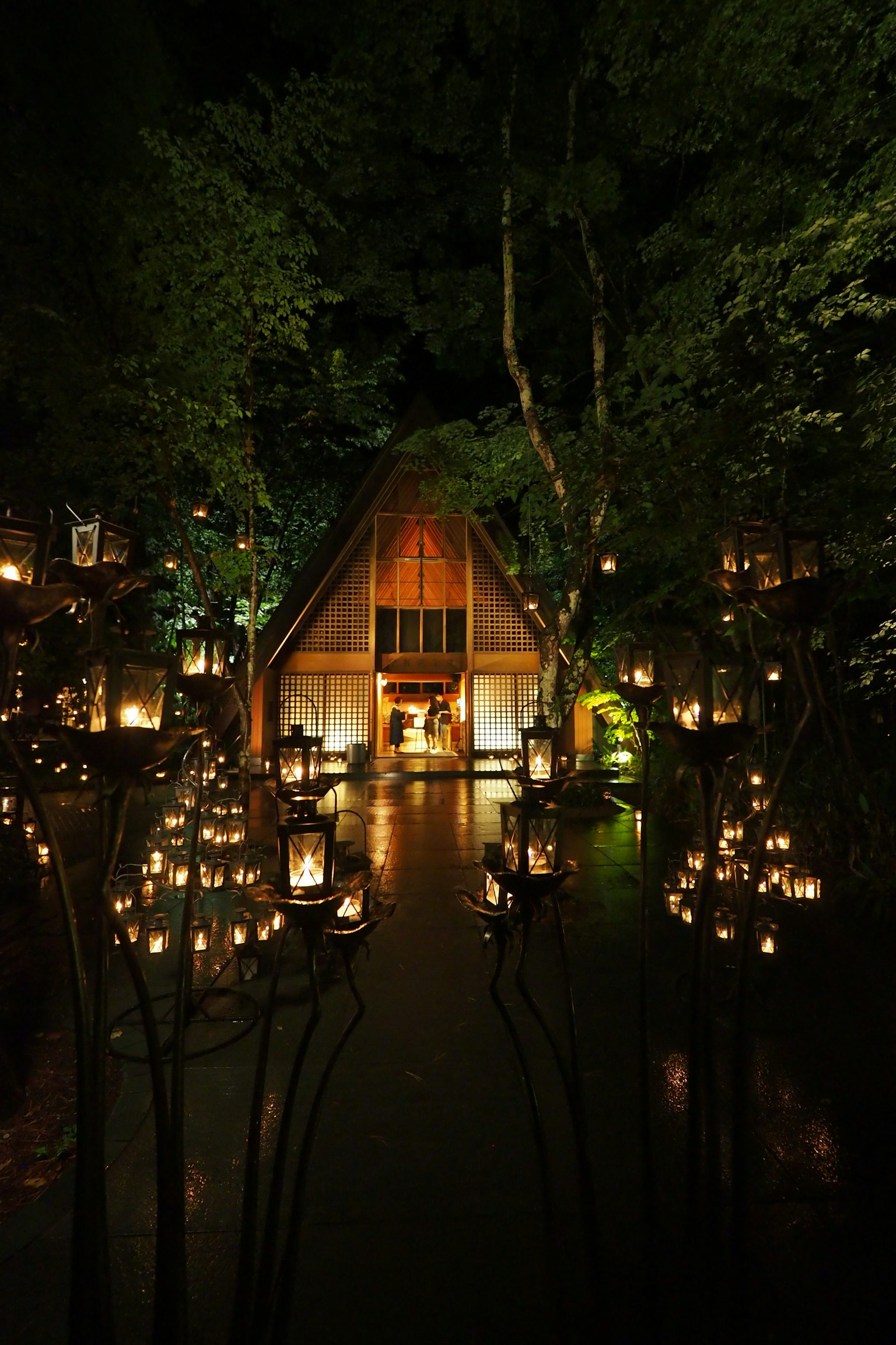 ทิวทัศน์ยามค่ำคืนของกระท่อมที่ส่องสว่างด้วยโคมไฟในป่า