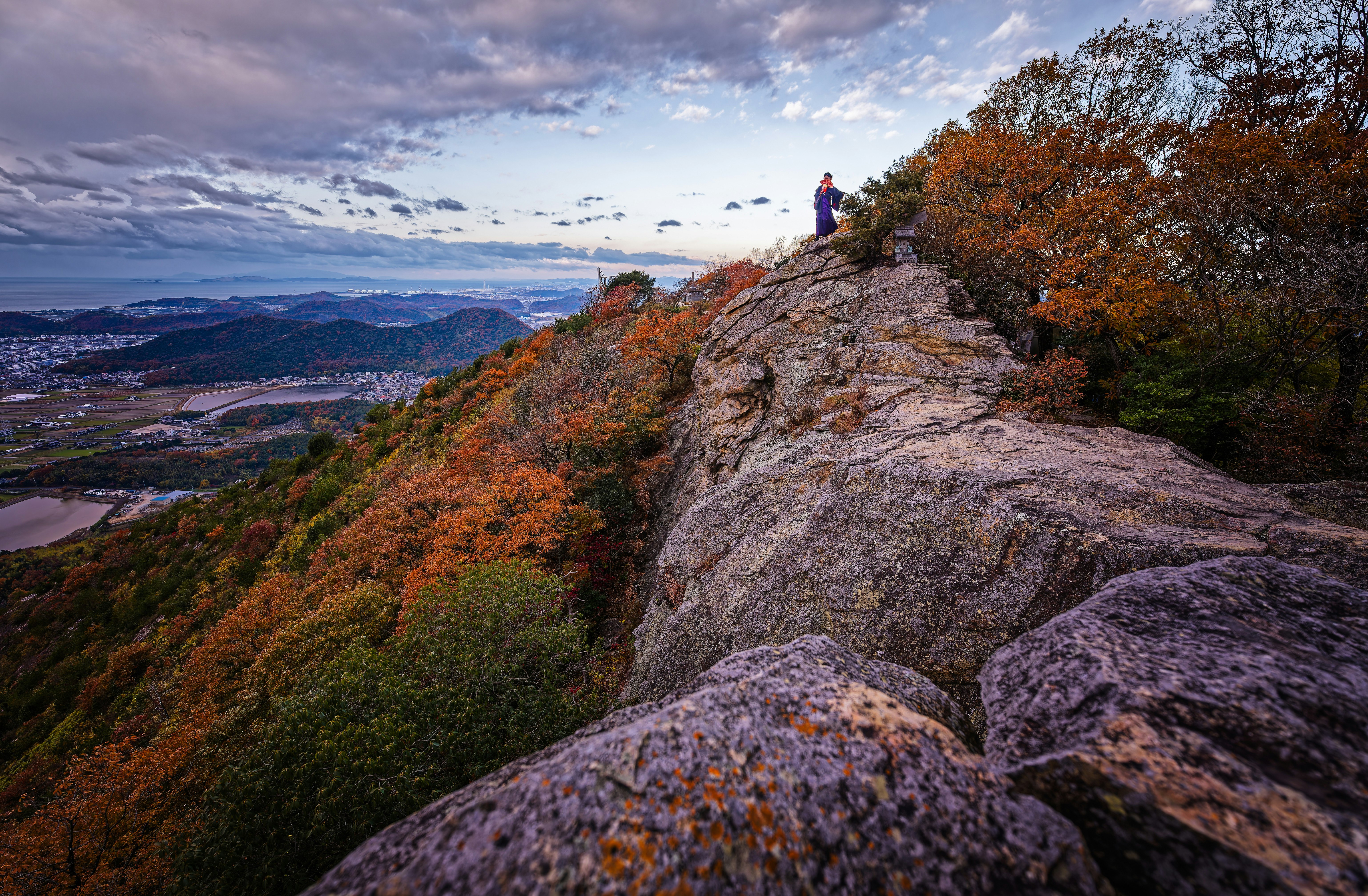 紅葉の岩場の稜線を歩く登山者の景色