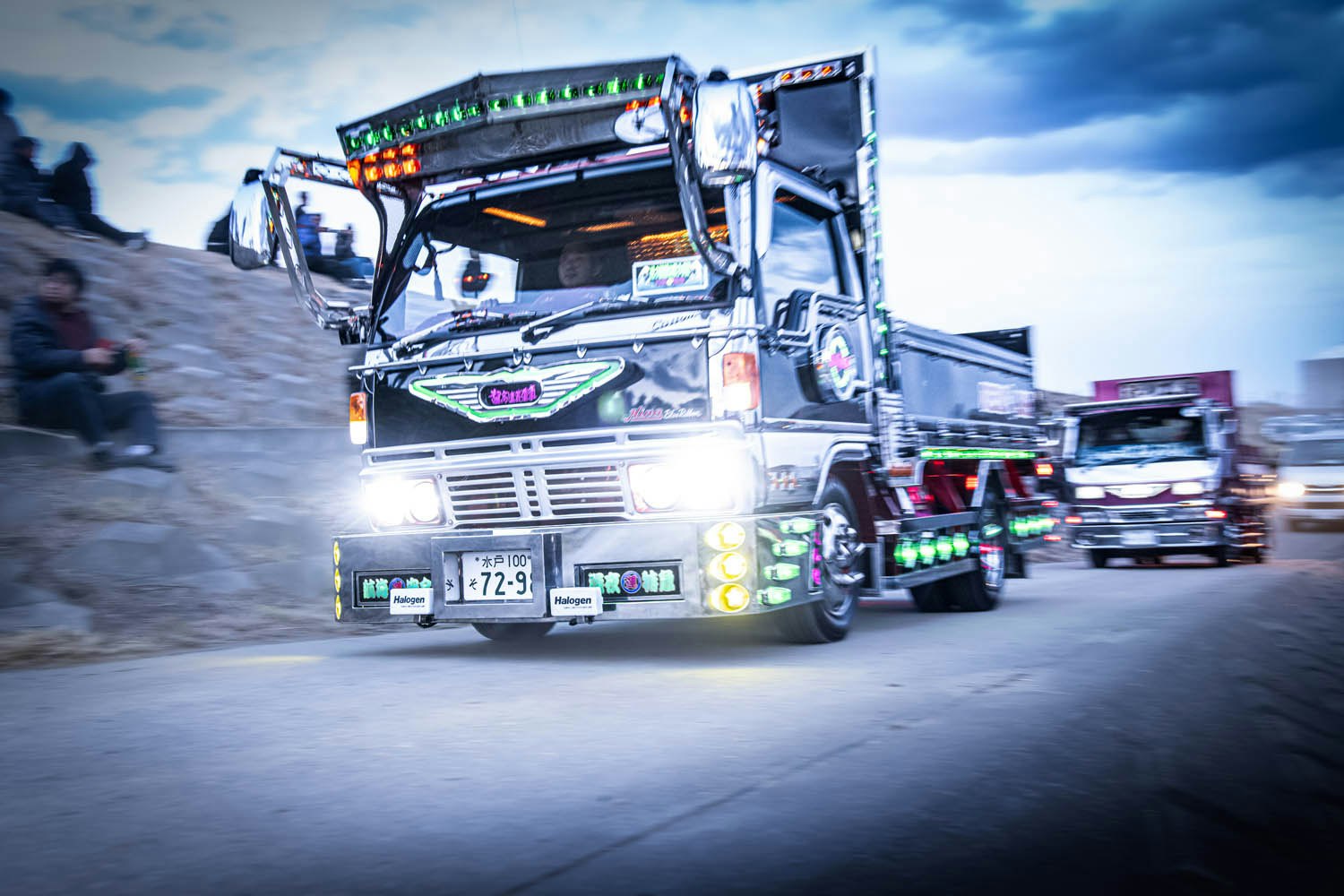 Night convoy of large trucks on a road