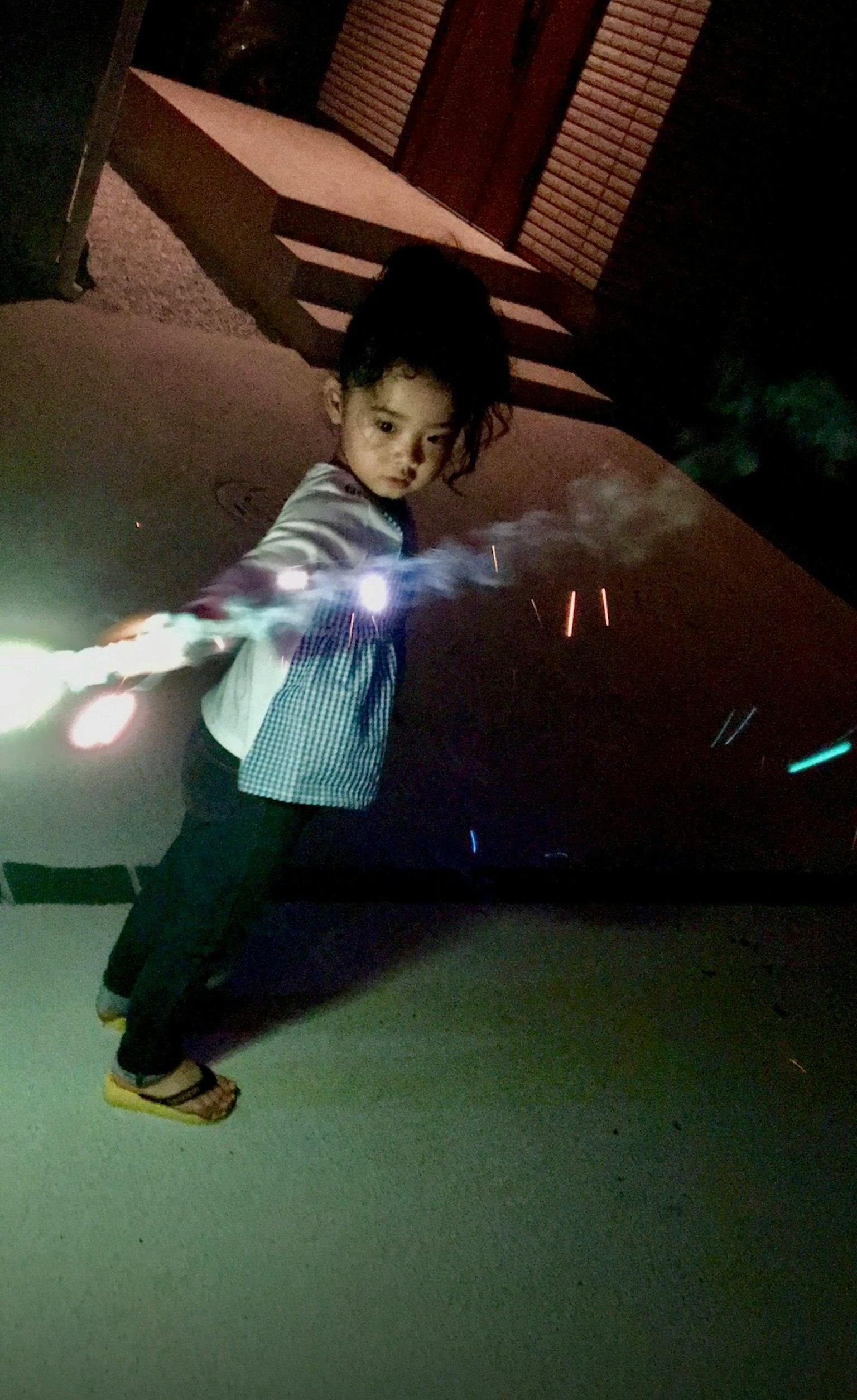 Kind schwingt einen leuchtenden Stock in einer Nachtszene