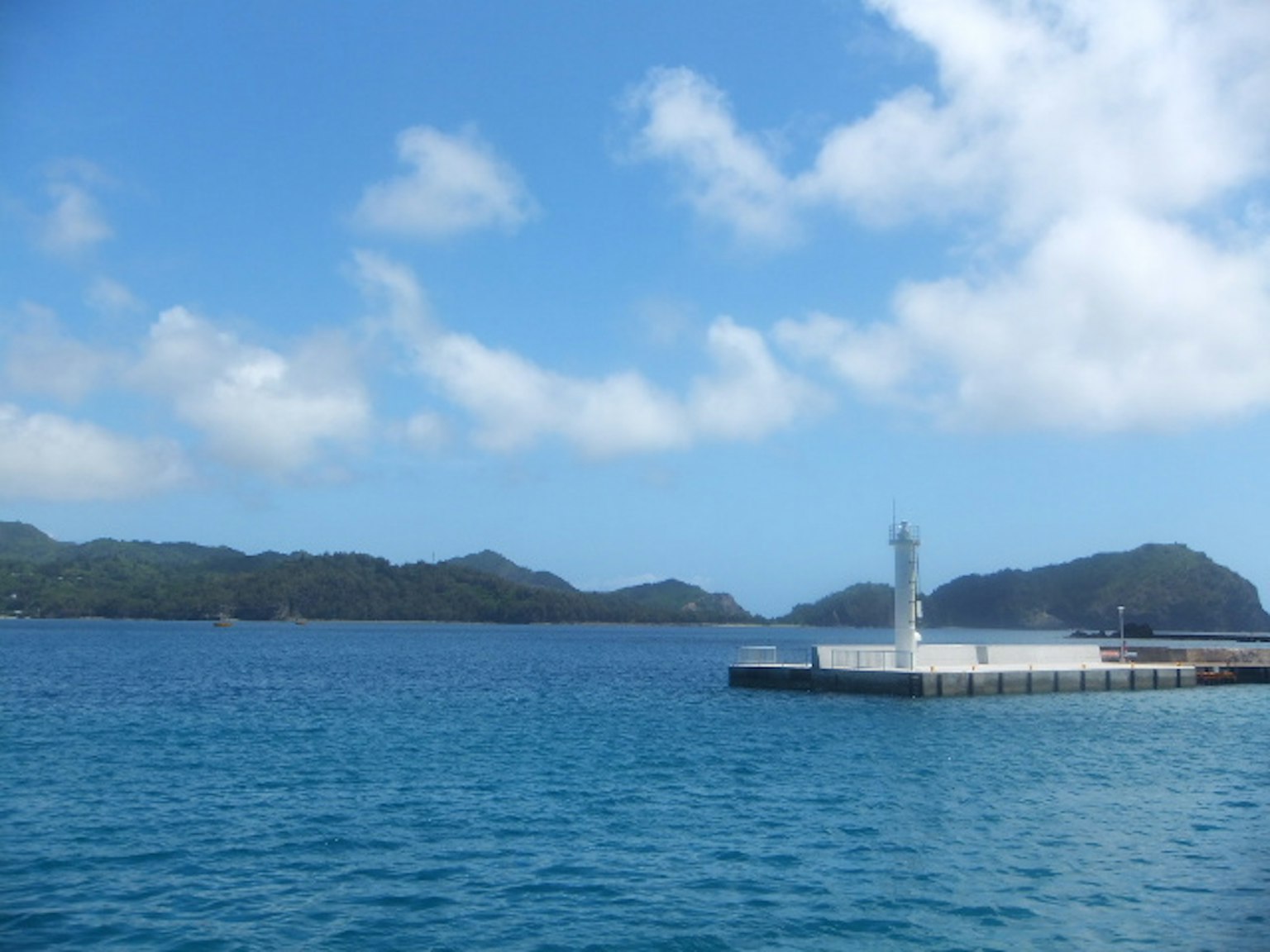 Hermosa escena de puerto con agua azul y nubes blancas