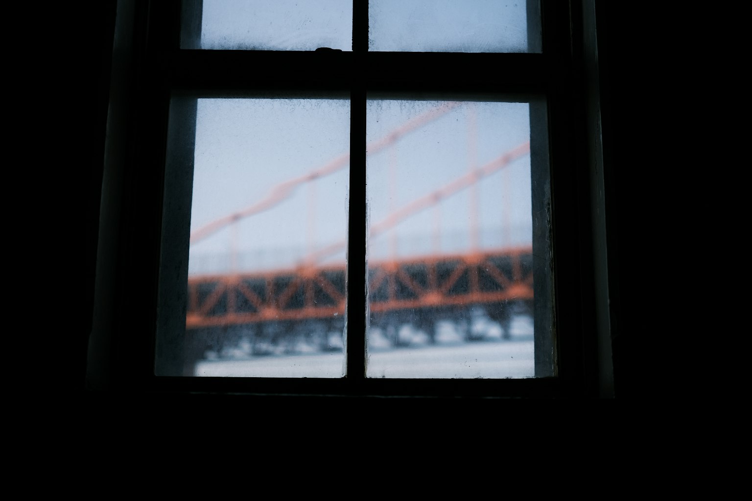 Blick auf eine orange Brücke durch ein beschlagenes Fenster