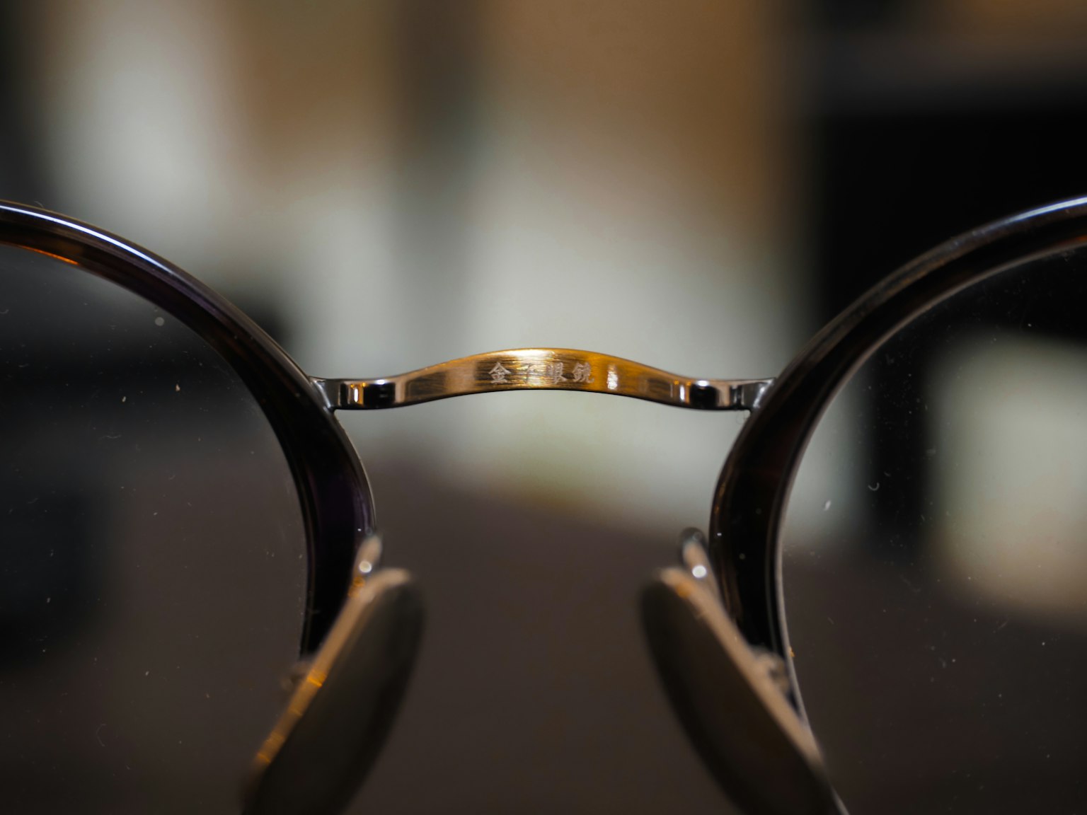 眼鏡のフレームの詳細なクローズアップ 金属製のブリッジと光沢のあるレンズ