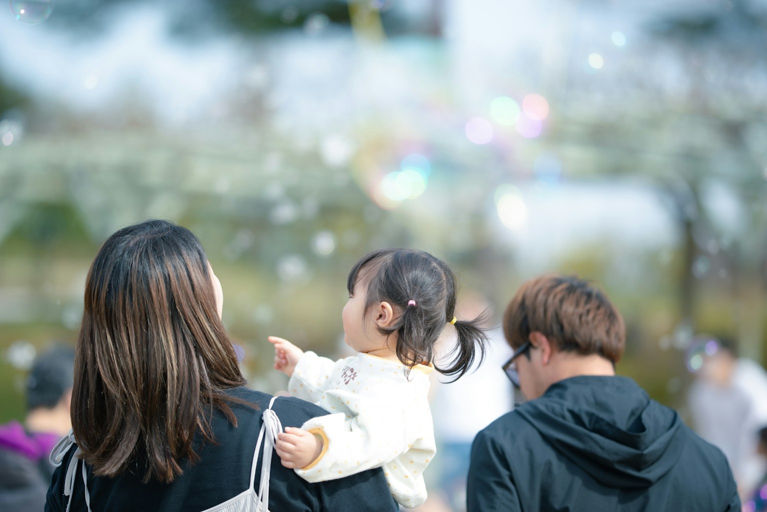 家庭在公园享受一天孩子指着泡泡