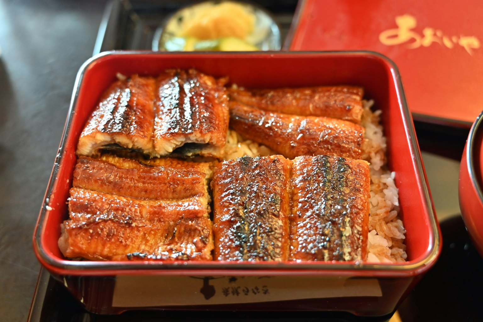 美味的鳗鱼饭装在红色便当盒中