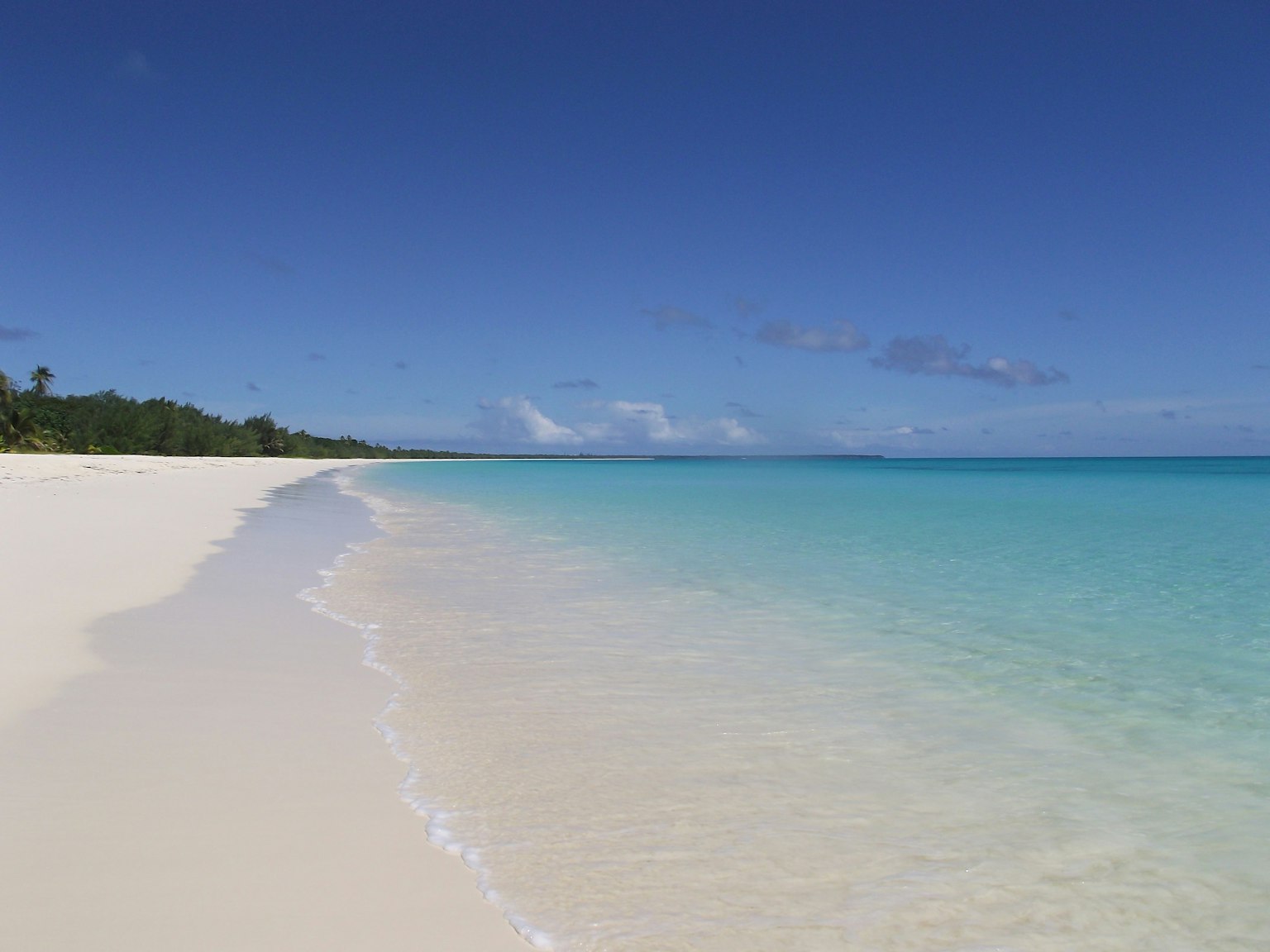 Pantai pasir putih yang indah dengan air biru kehijauan