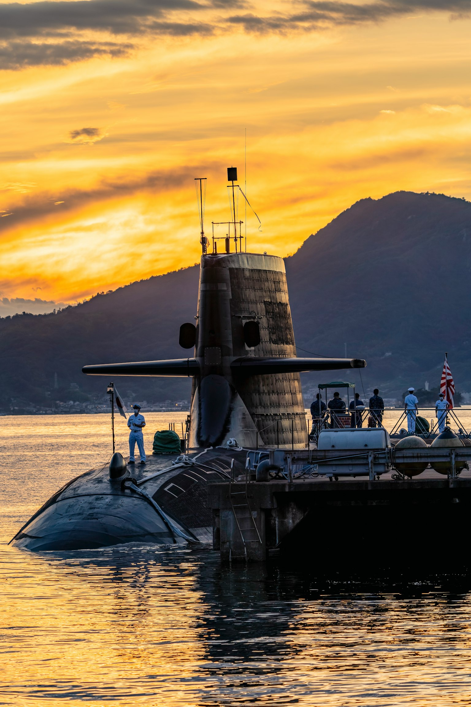 เรือดำน้ำโผล่ขึ้นในยามพระอาทิตย์ตกพร้อมคนรอบข้าง