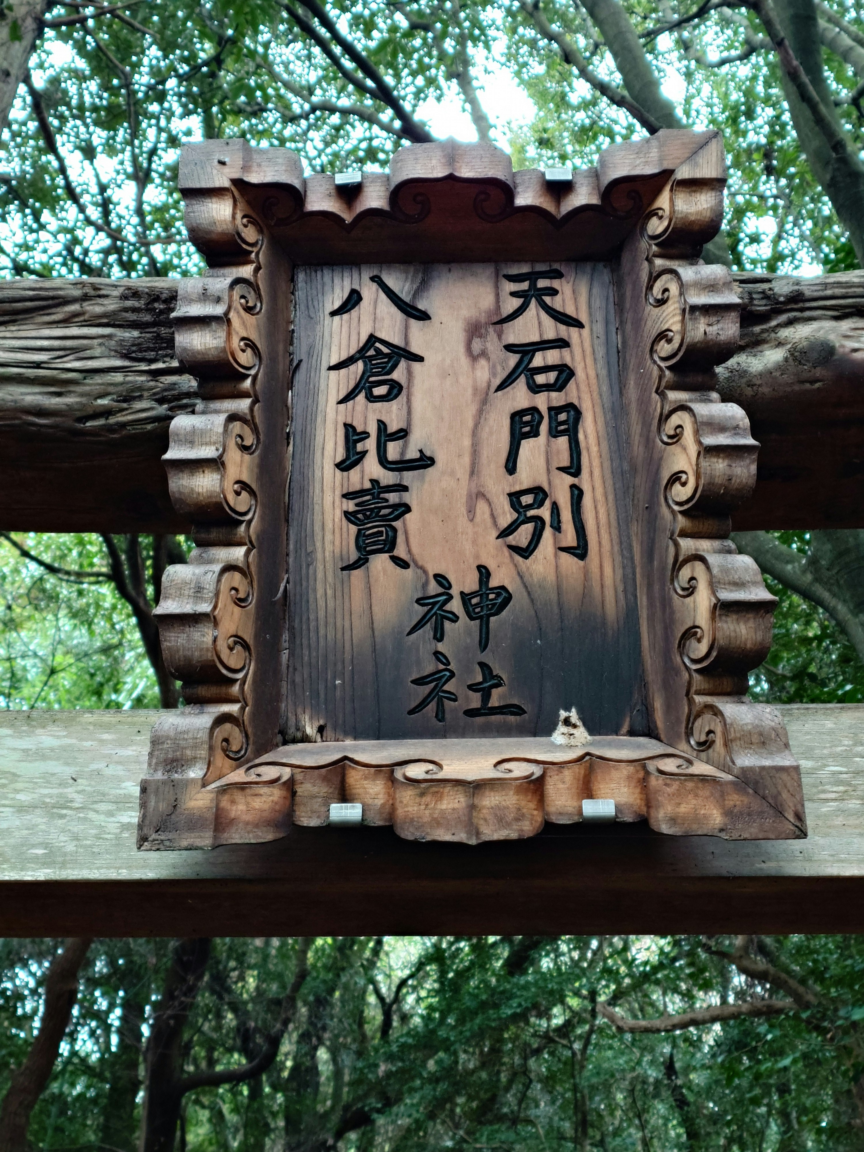 木の鳥居に掲げられた「天石門別八倉比売神社」の扁額