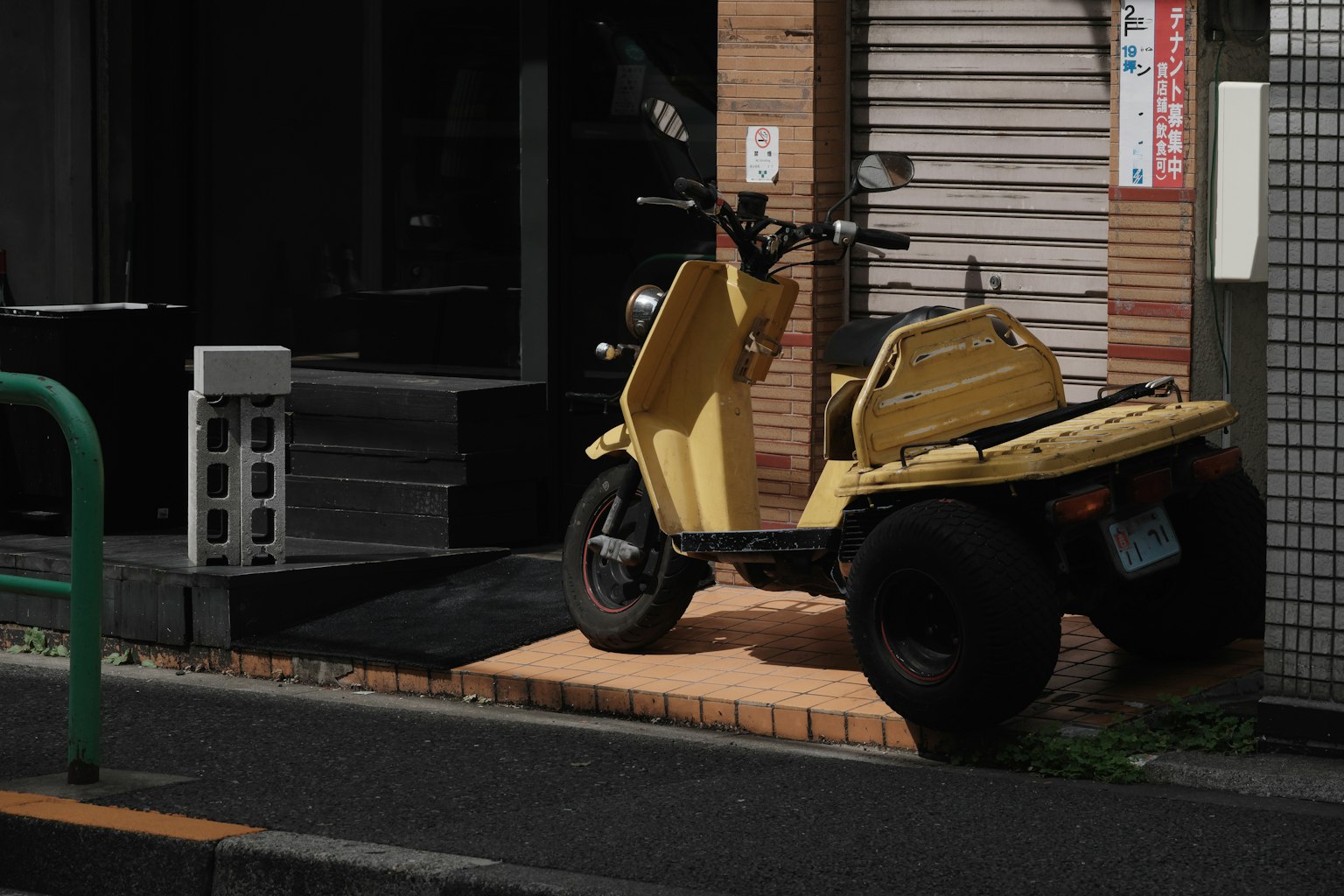 停在人行道上的黃色三輪滑板車