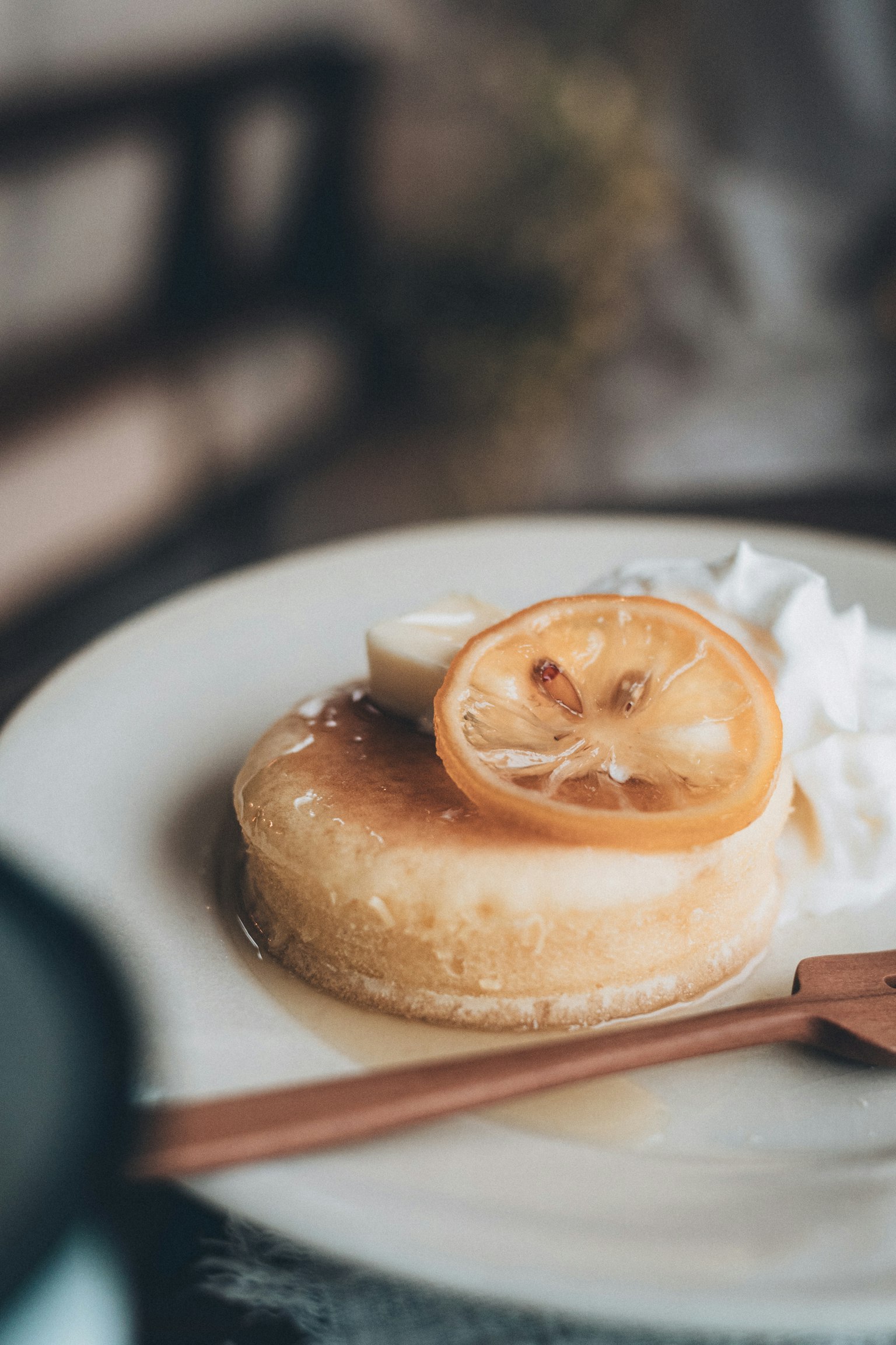 Postre cremoso cubierto con una rodaja de limón y crema batida en un plato