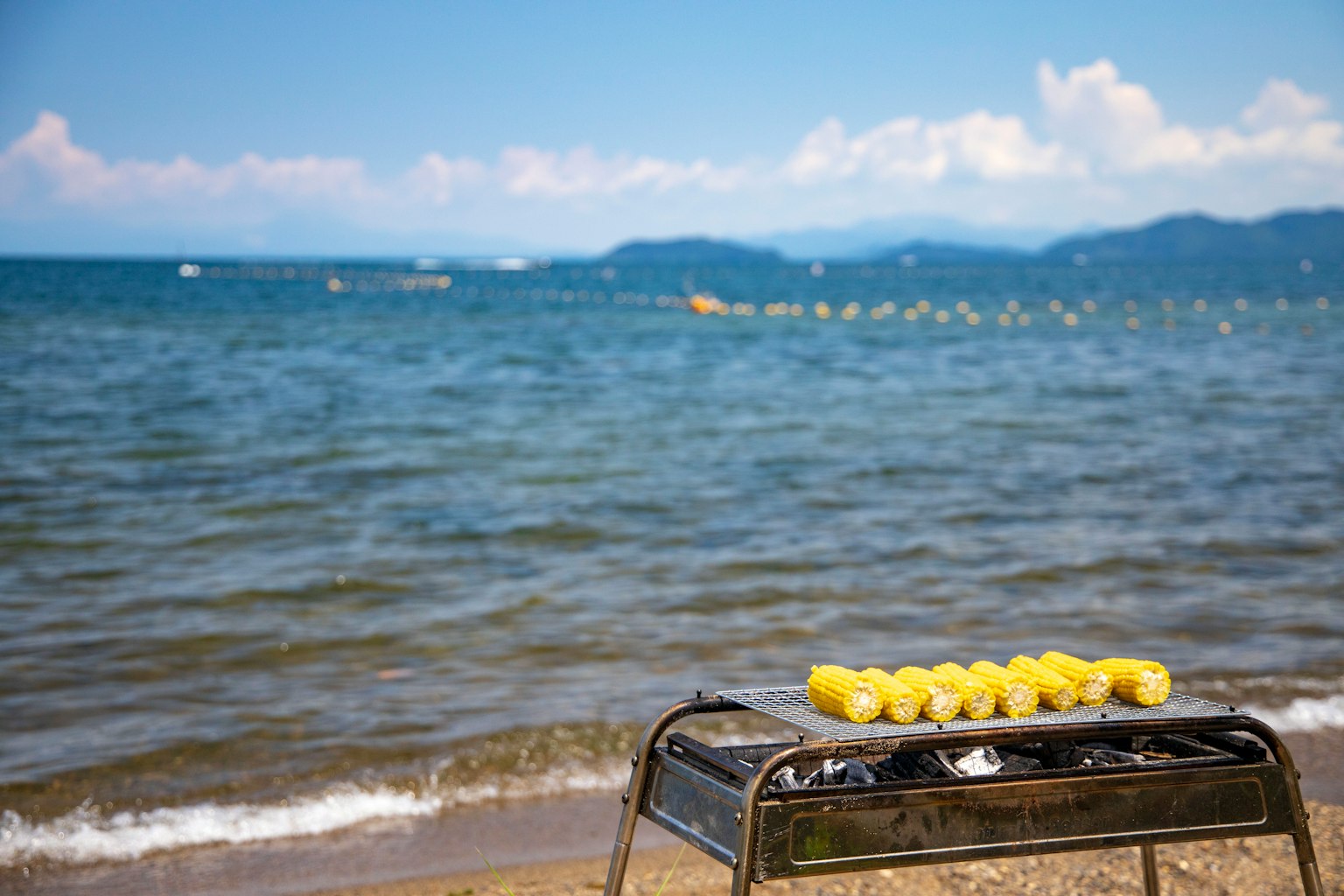 Grill mit gelben Lebensmitteln am Strand