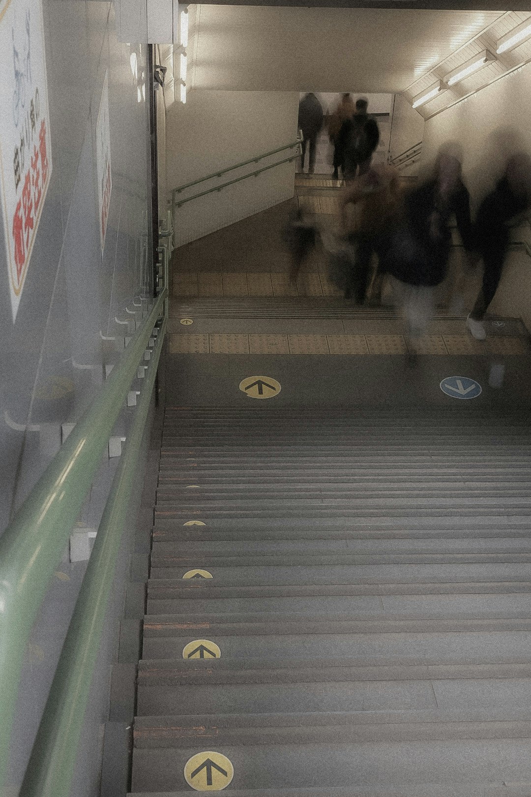 Menschen, die in einem unterirdischen Bahnhofsgang und auf Treppen gehen