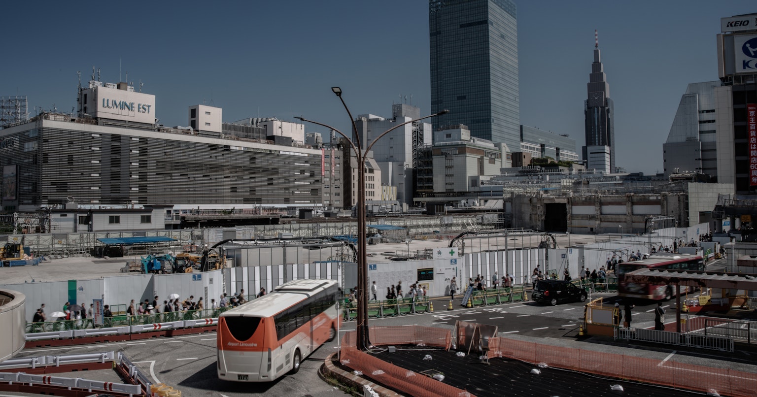 Site de construction urbain avec un bus visible bâtiments et grues en arrière-plan