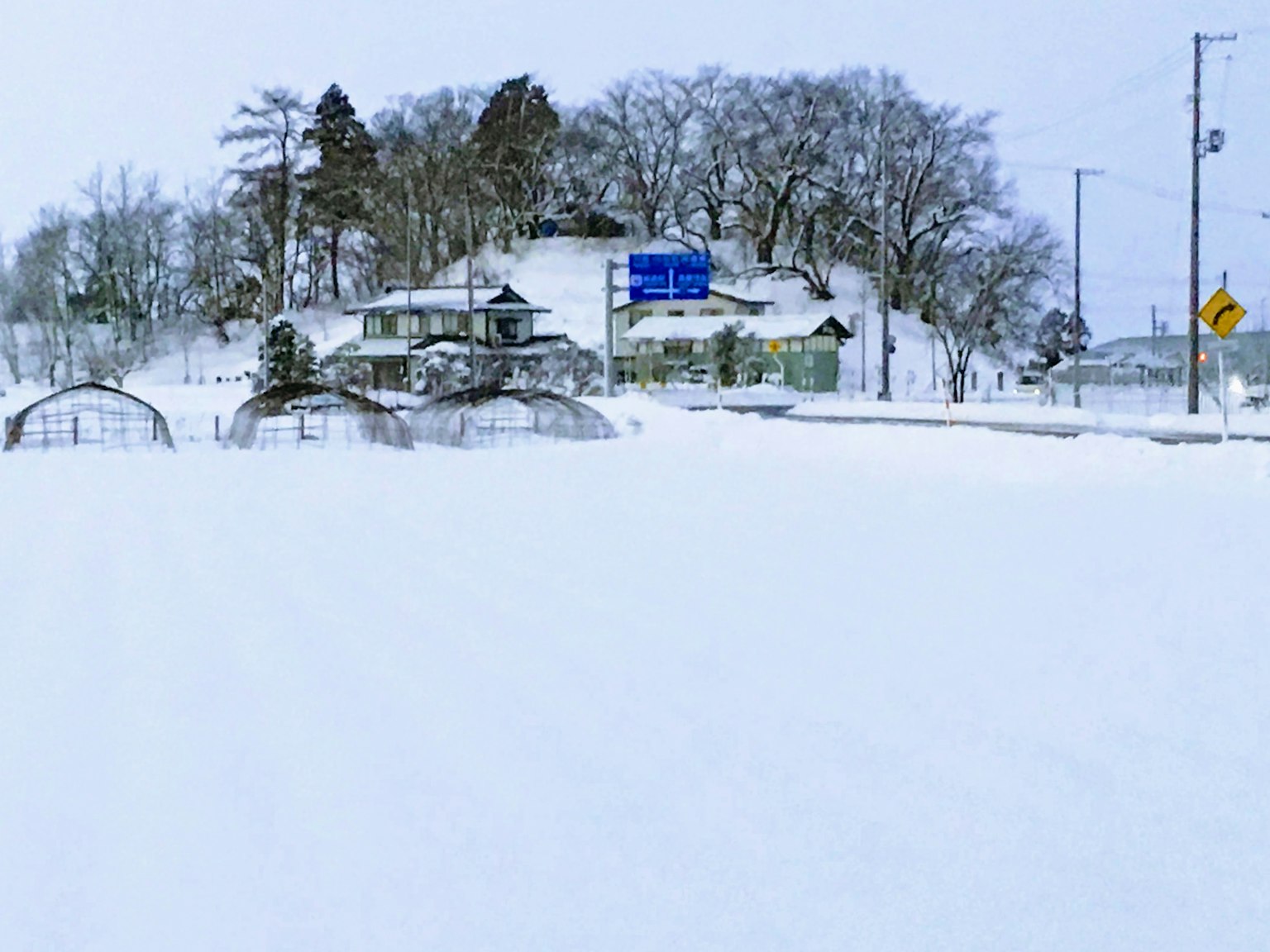 Paysage enneigé avec une maison et des panneaux de signalisation
