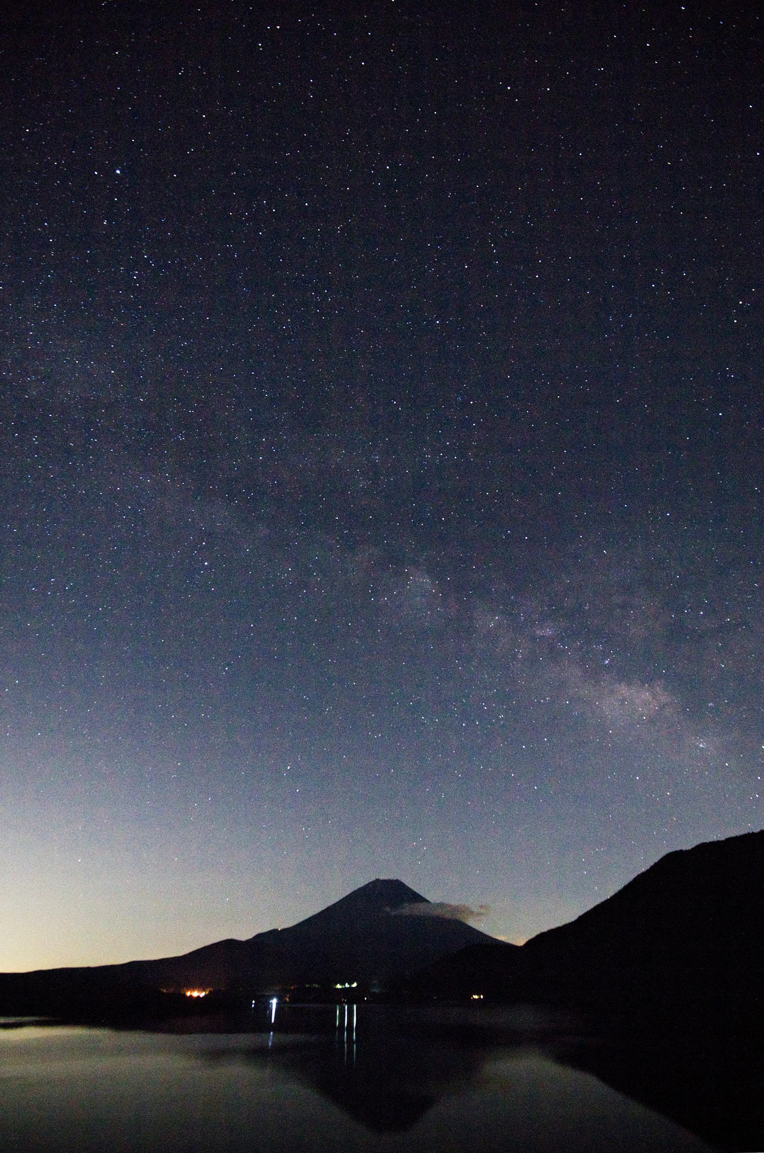 Langit berbintang yang memantul di danau tenang dengan Gunung Fuji