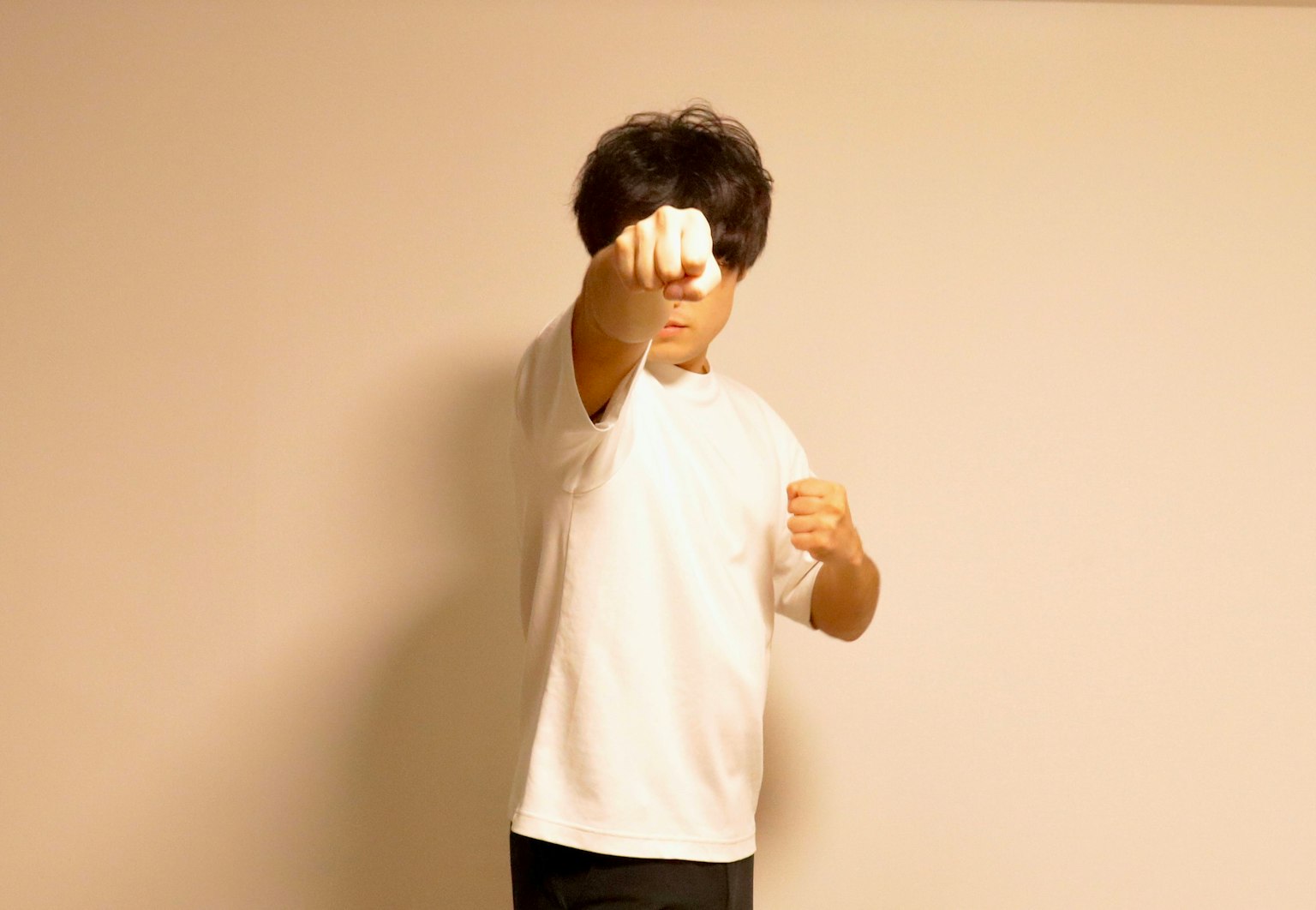 A man in a white shirt striking a punching pose