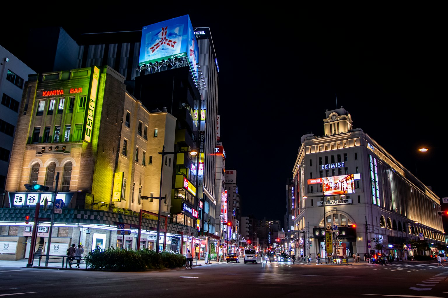 Paesaggio urbano notturno con edifici illuminati e luci al neon