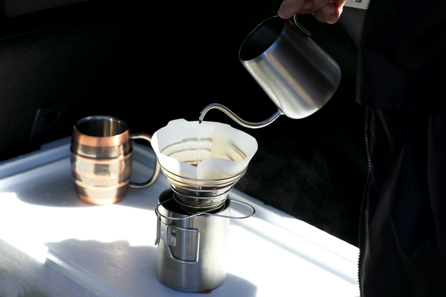 Sebuah perangkat penyeduhan kopi perak dengan filter dan kopi yang dituangkan